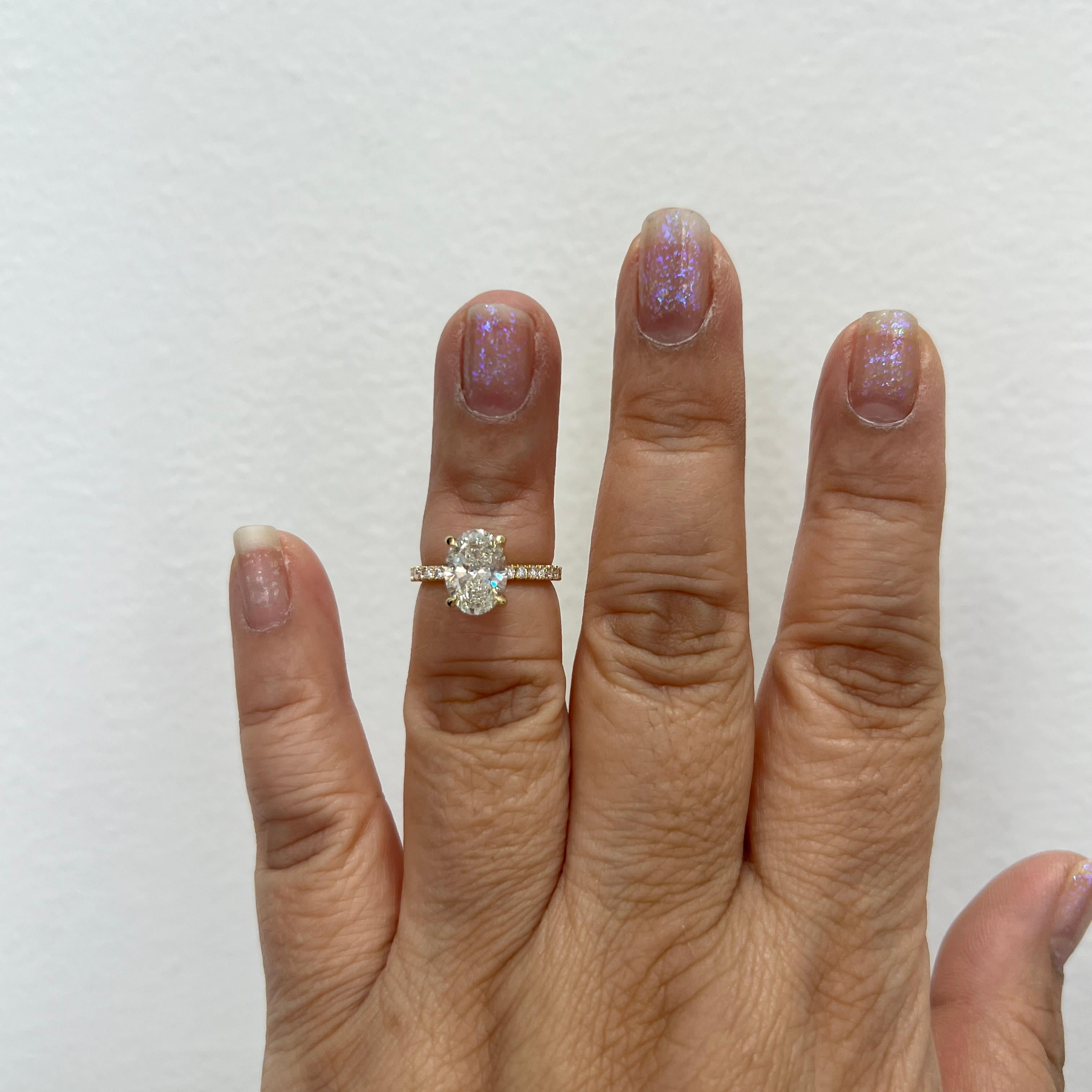 Beautiful 2.02 ct. K SI2 white diamond oval with smaller good quality white diamond rounds.  Handmade in 18k yellow gold.  Ring size 4.75.  Comes with GIA certificate.  Ring can be resized.