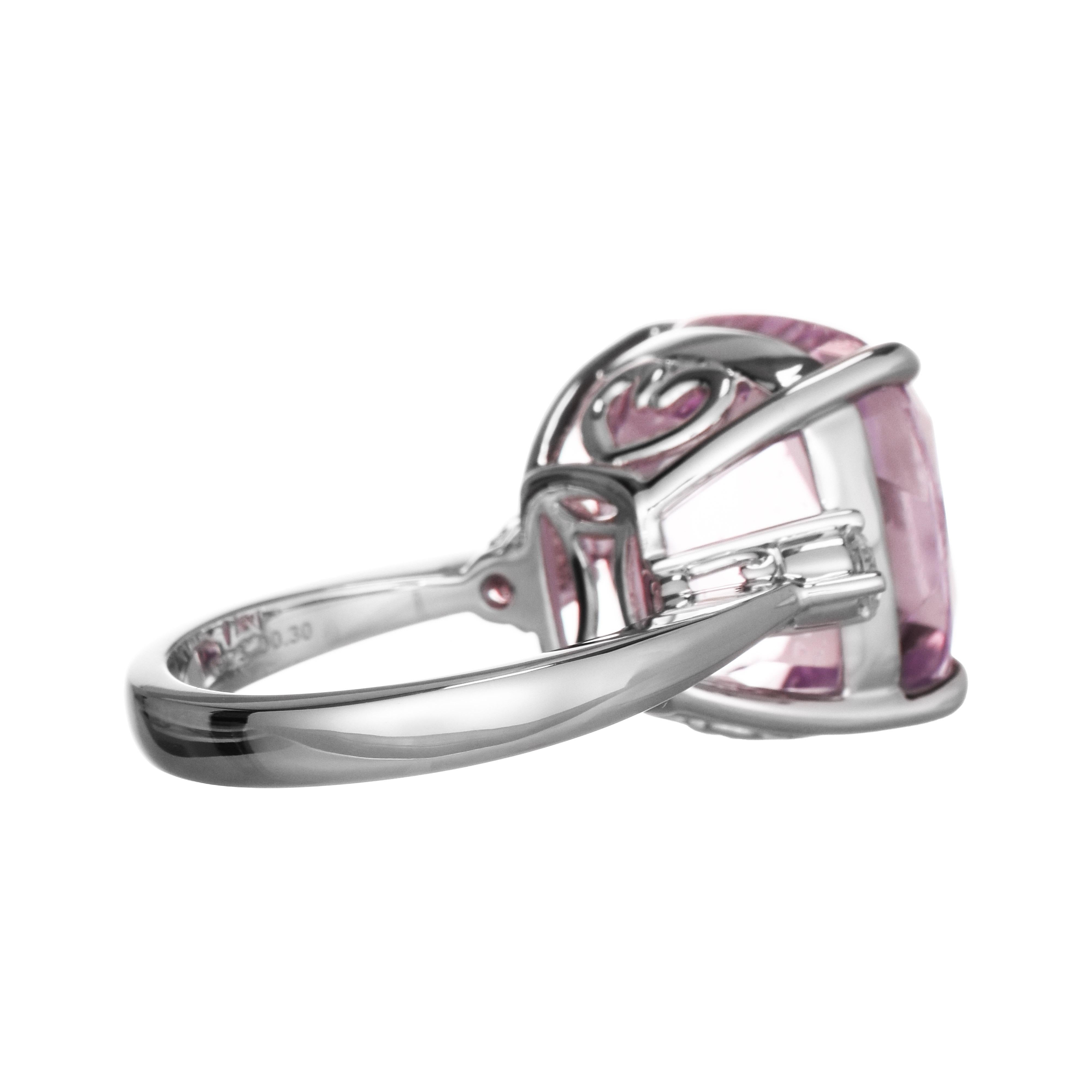 A captivating ring featuring a large kunzite gemstone, set in a sleek white gold band. This ring is accented by two sparkling diamonds on the sides of the center stone, enhancing its elegance.

1 Kunzite Gemstone: 19.73 Carats, Cushion Cut
2 White