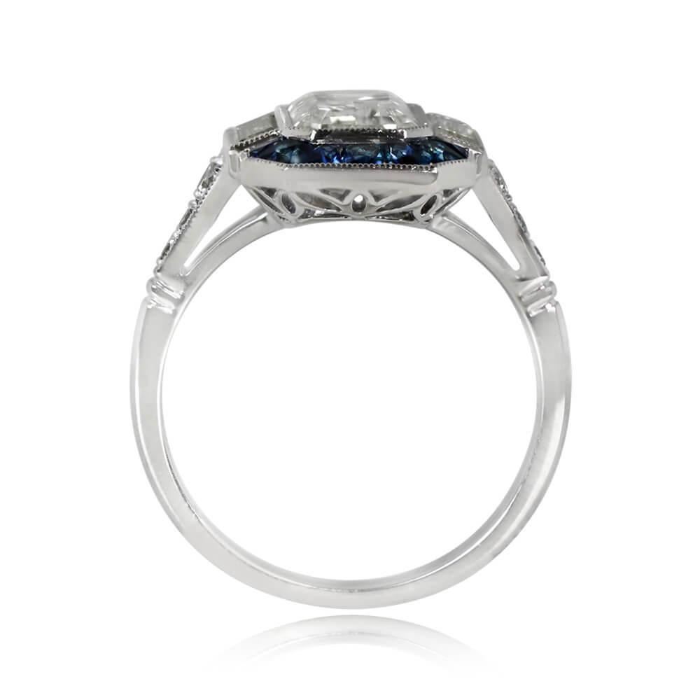 Cette bague halo en diamant et saphir présente un diamant émeraude de 2,00 carats certifié par le GIA, de couleur L et de pureté SI1, élégamment serti d'un chaton flanqué de diamants baguettes. Un halo enchanteur de saphirs de taille française