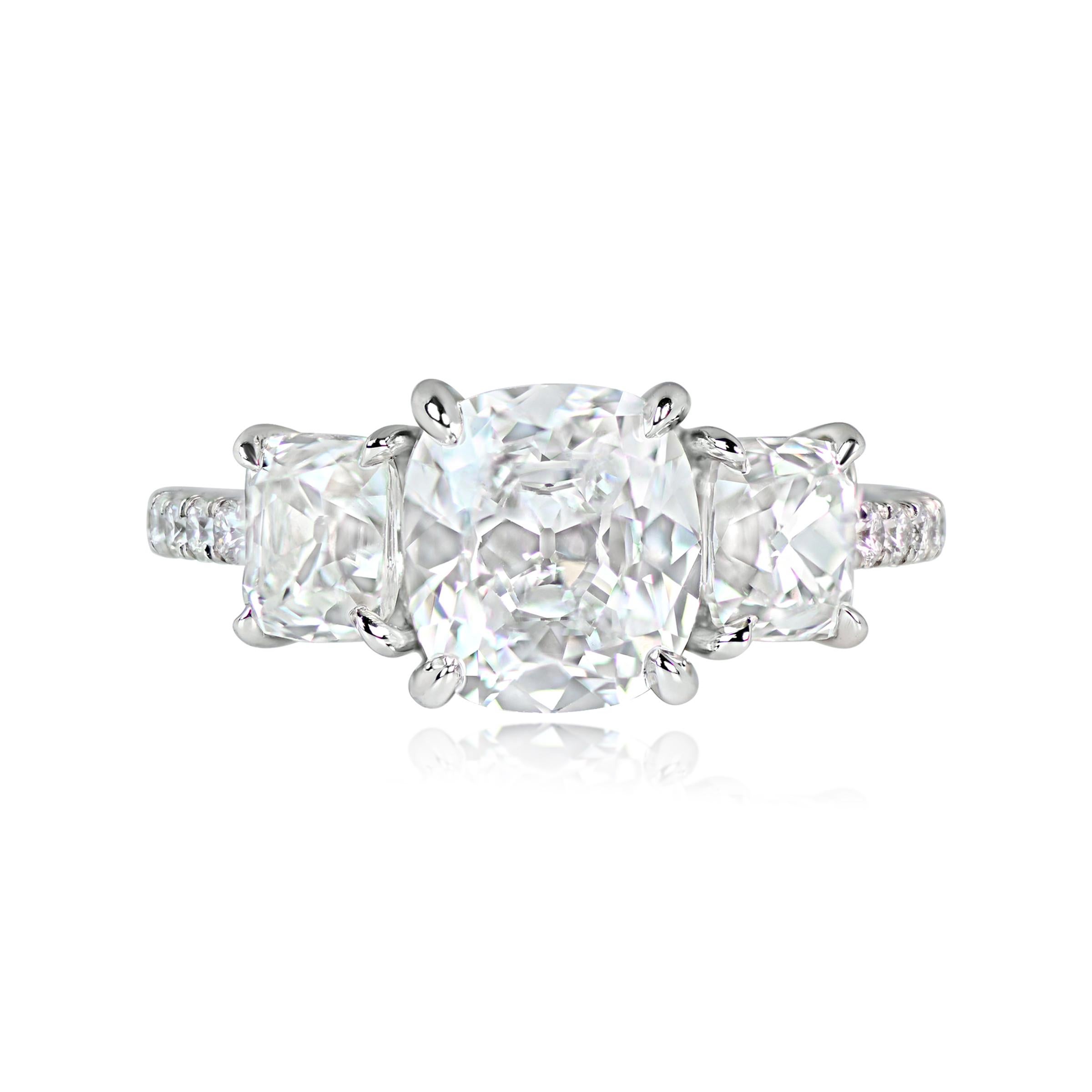 This is a stunning platinum and diamond three-stone ring with an antique cushion cut diamond at the center, weighing 2.01 carats and certified by the GIA as D color and VVS2 clarity. The two smaller antique cushion cut diamonds flanking the center
