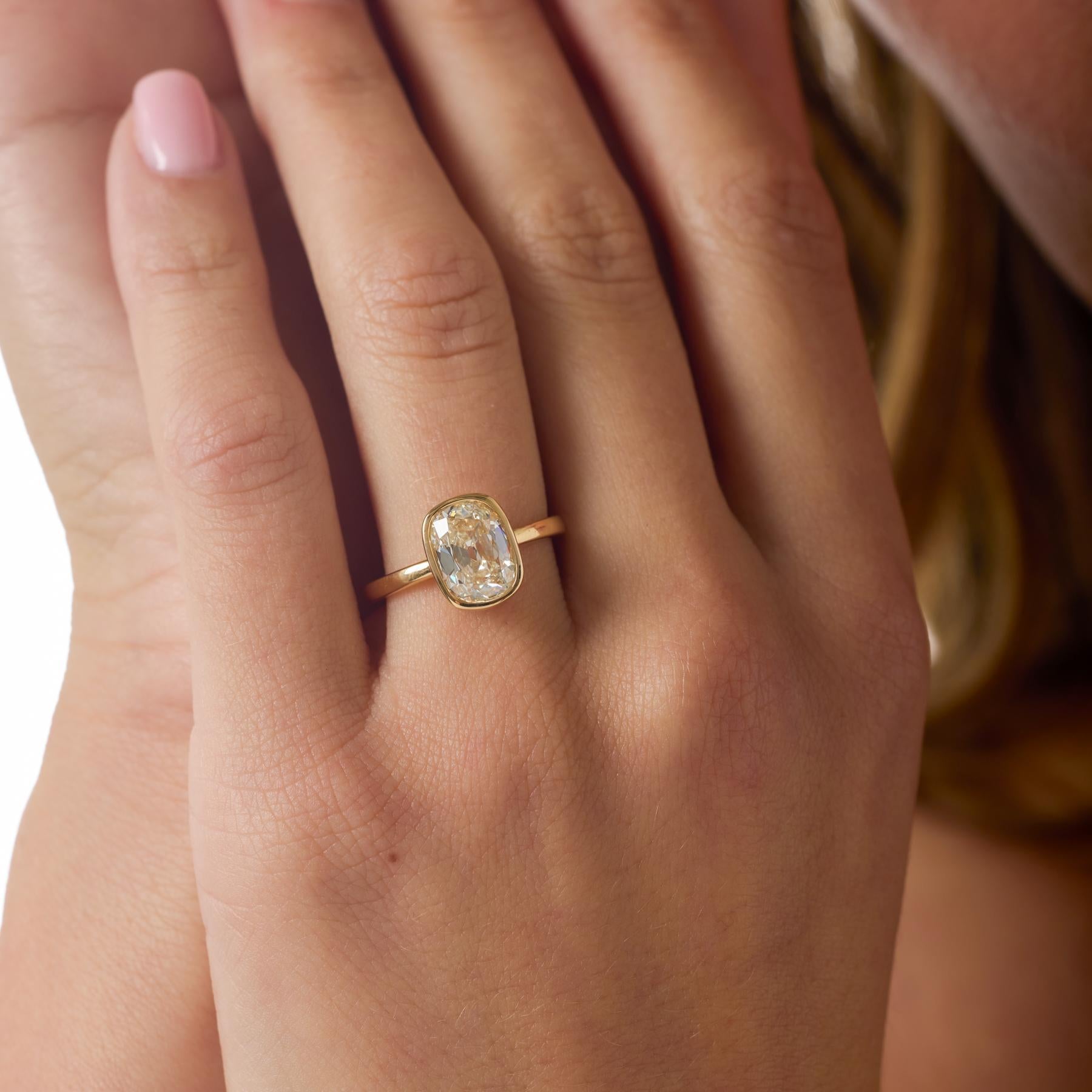 Rayonnante et pleine de caractère, cette bague de fiançailles moderne met en valeur un diamant coussin brillant de 2,01 carats certifié par la GIA, dont l'influence des anciennes mines lui confère un éclat doux et romantique. Sa couleur J et sa