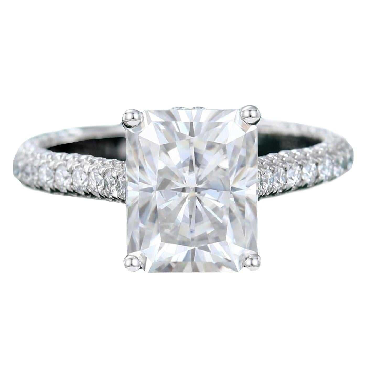 Cette magnifique bague à taille rayonnante est ornée d'une pierre centrale de 2,01 carats et d'un diamant de taille ronde en sertissage pavé. Le sertissage est de couleur D et de pureté Si1. La bague est élégante et intemporelle, parfaite pour toute