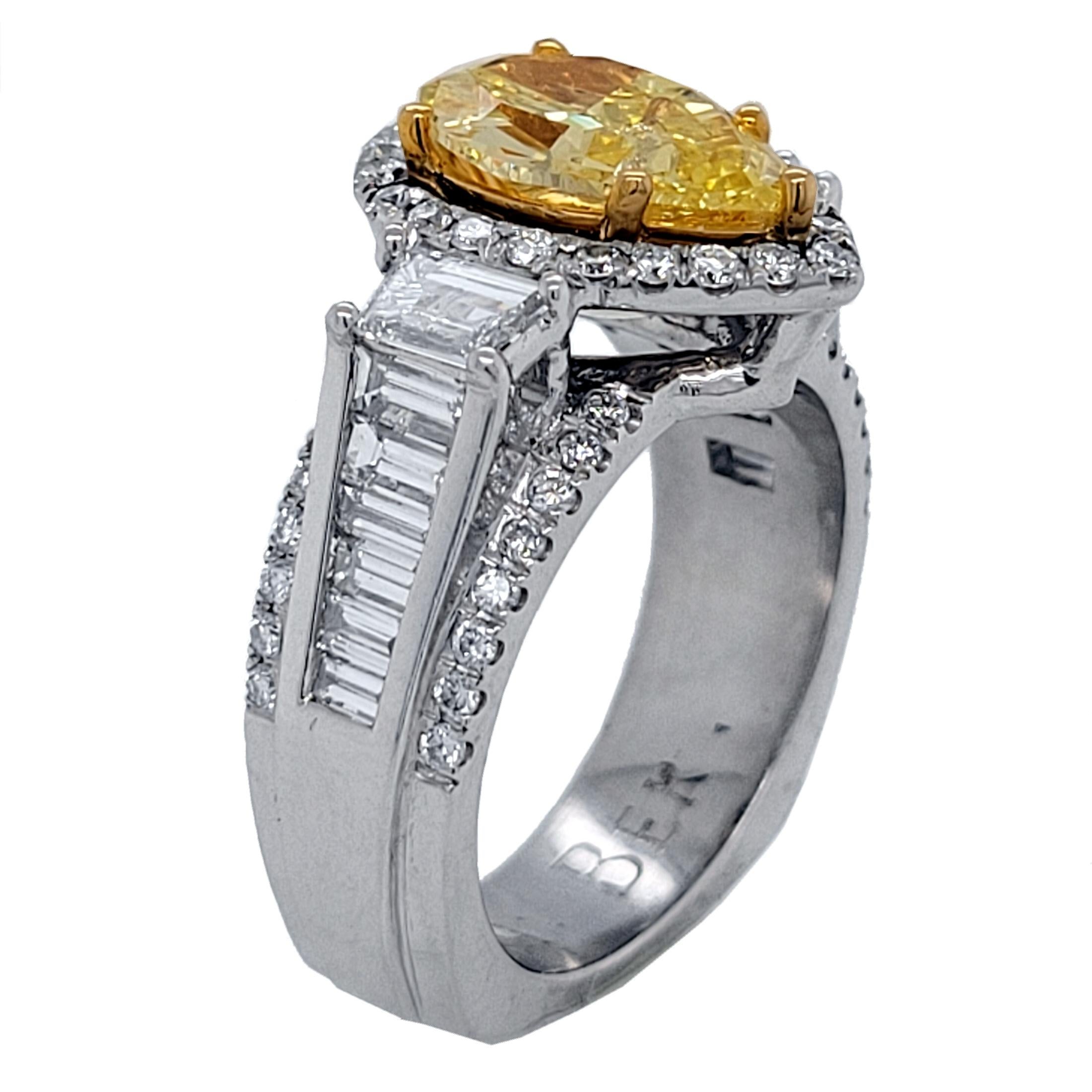 Un magnifique diamant central certifié GIA de couleur jaune intense naturel en forme de poire serti dans une magnifique bague de fiançailles en platine pavée de deux diamants trapézoïdaux sur le côté et d'une série de diamants baguettes sertis en