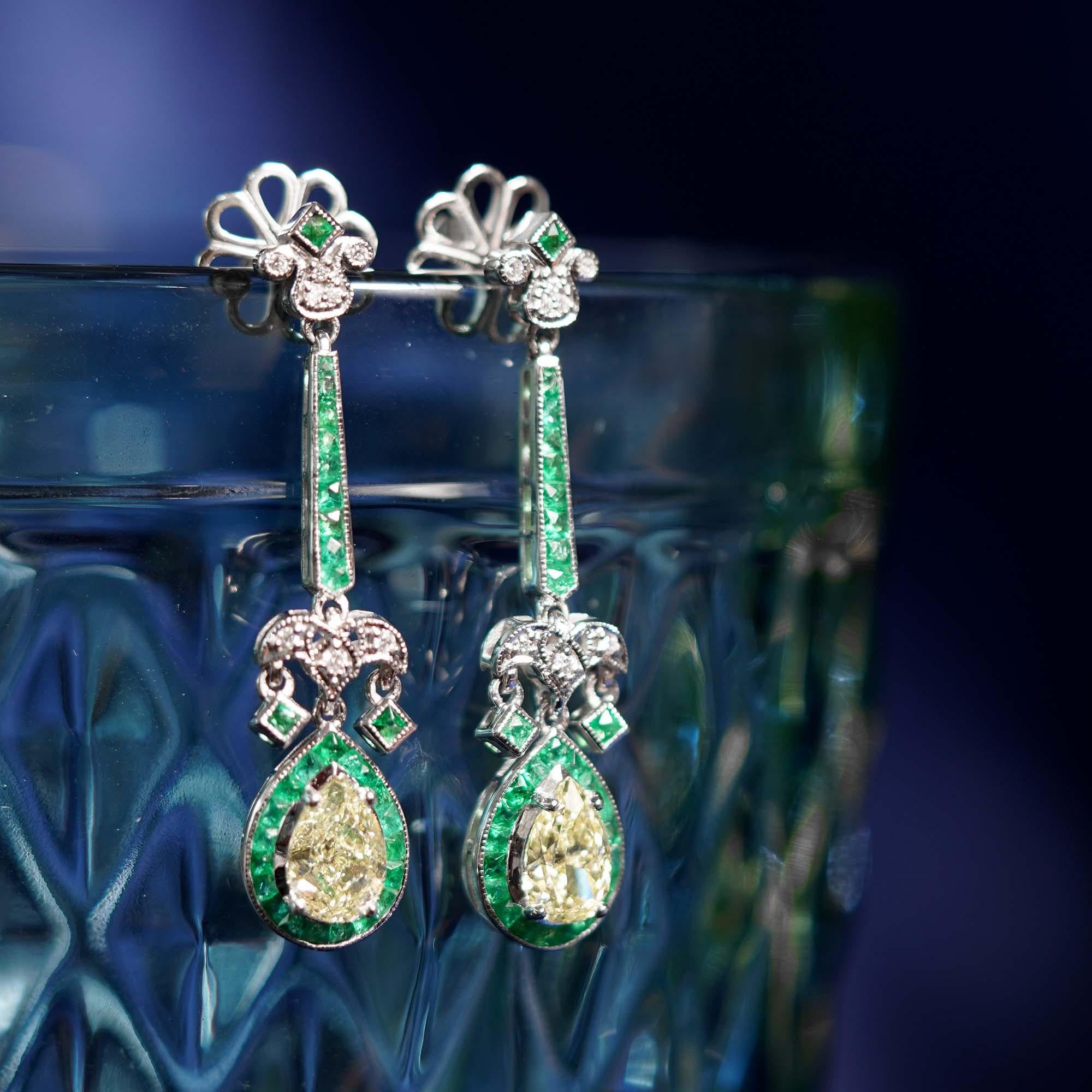 Inspired by the iconic Art Deco era, these fabulous earrings were designed for a true wow factor. Featuring total 2.25 carats weight of pear shape yellow diamonds surrounded by French cut emeralds. Create your stunning look with these lovely