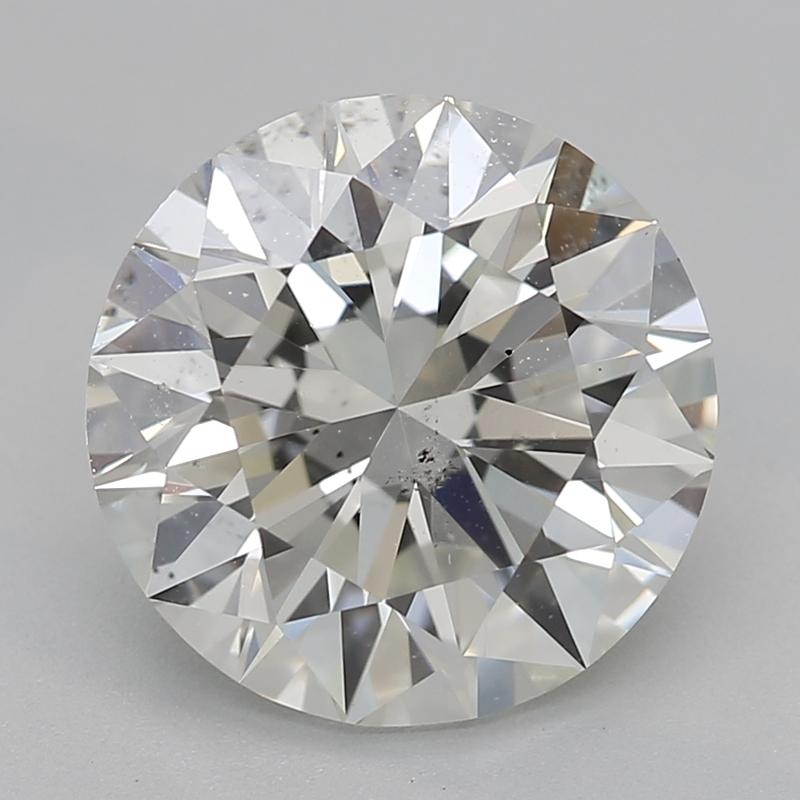 Fabriquée à la main à New York, cette magnifique bague en diamant présente en son centre un diamant rond captivant, d'un poids impressionnant de 2,2, complété par un J exquis et un SI1. Le design unique met en valeur un top signet à lunette