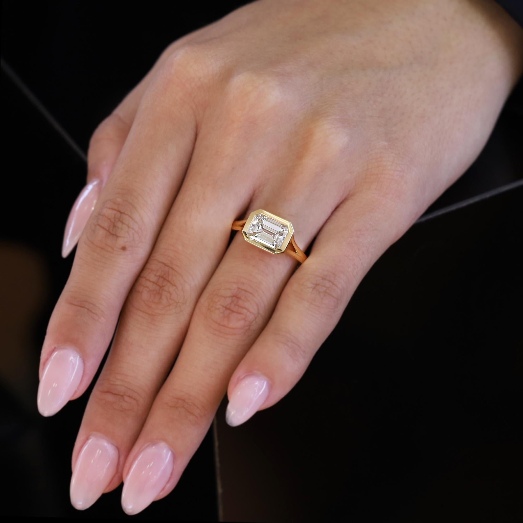 Wir haben diesen wunderschönen Diamanten im Smaragdschliff (2,30) aus einem alten Verlobungsring gerettet und ihn in diesem eleganten, modernen Solitärring aus 18 Karat Gelbgold wiederverwendet. Der GIA-zertifizierte Diamant wird als L-Farbe