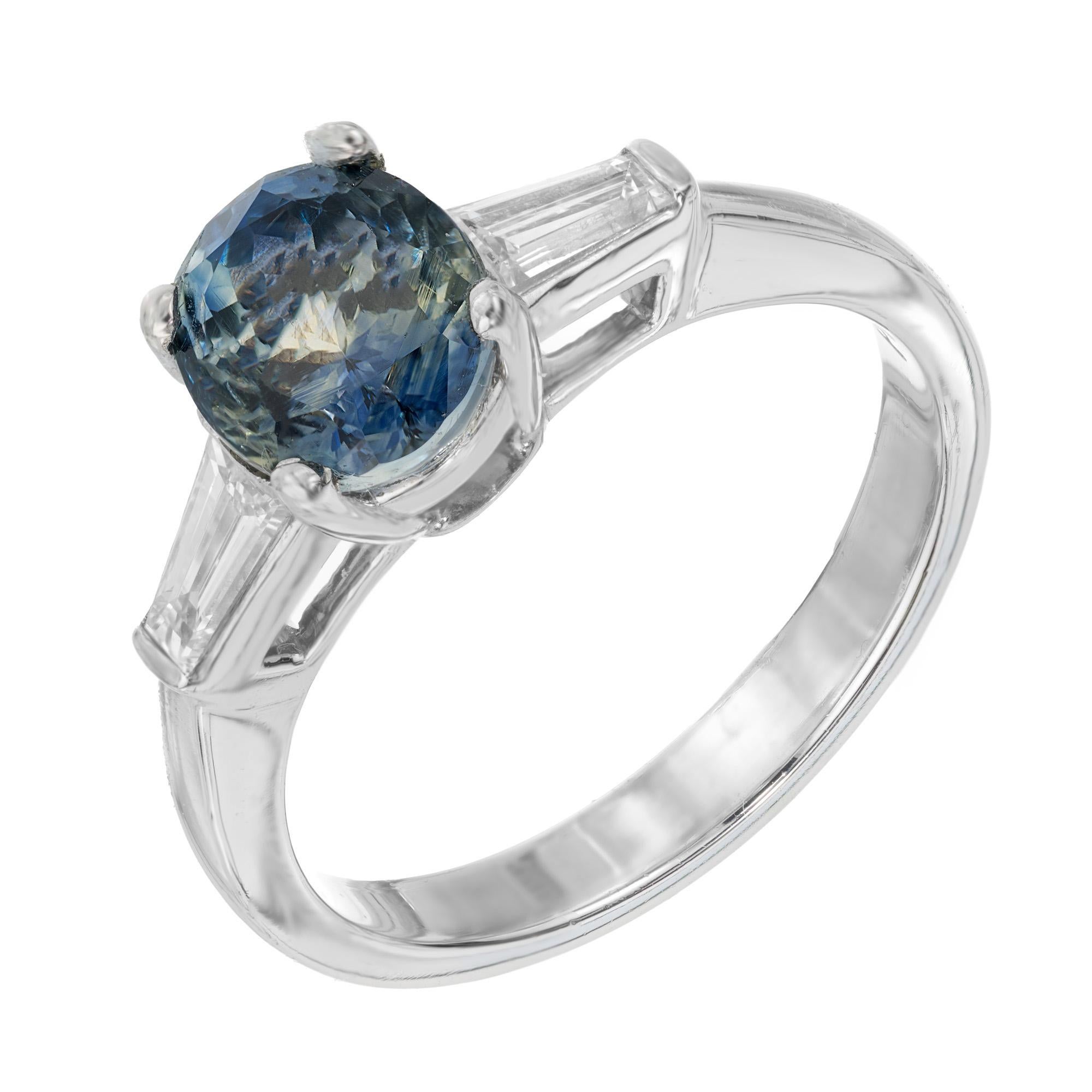 Blue and green sapphire and baguette engagement ring. This unique GIA certified oval center sapphire, is blue at both ends of the stone with a light green middle. It is certified as natural, no heat. Set in a three stone platinum setting with 2
