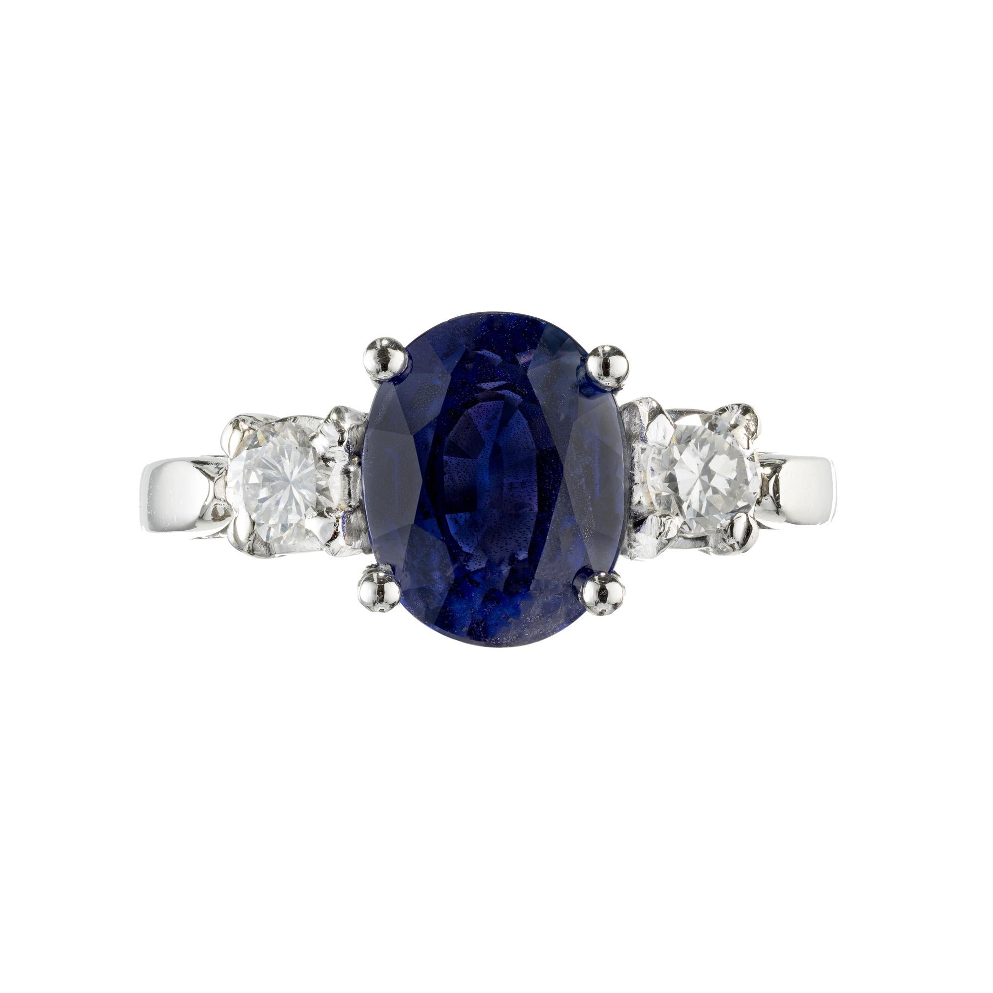 Three-stone sapphire and diamond engagement ring. GIA certified Fancy color natural no heat, no enhancement oval Sapphire center stone. Set in a platinum three-stone setting with 2 brilliant cut side diamonds. 

1 Rare gem cornflower oval blue