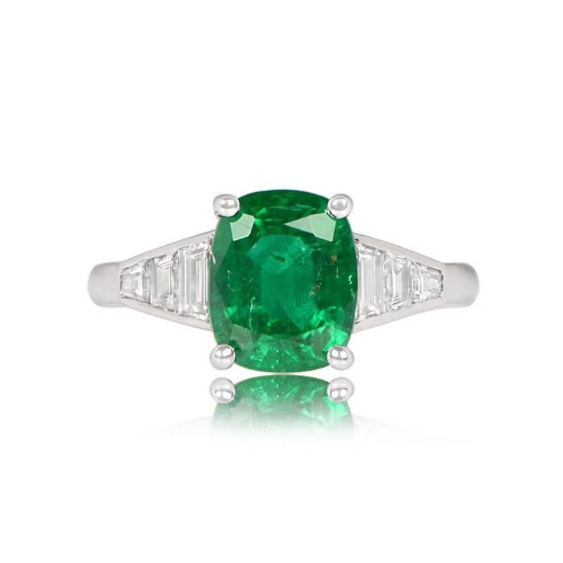 A stunning gemstone ring showcases a 2.48-carat GIA-certified green cushion-cut natural emerald with exceptional saturation. The emerald is elegantly prong-set in 18k white gold, and the ring's shoulders are adorned with tapered baguette-cut