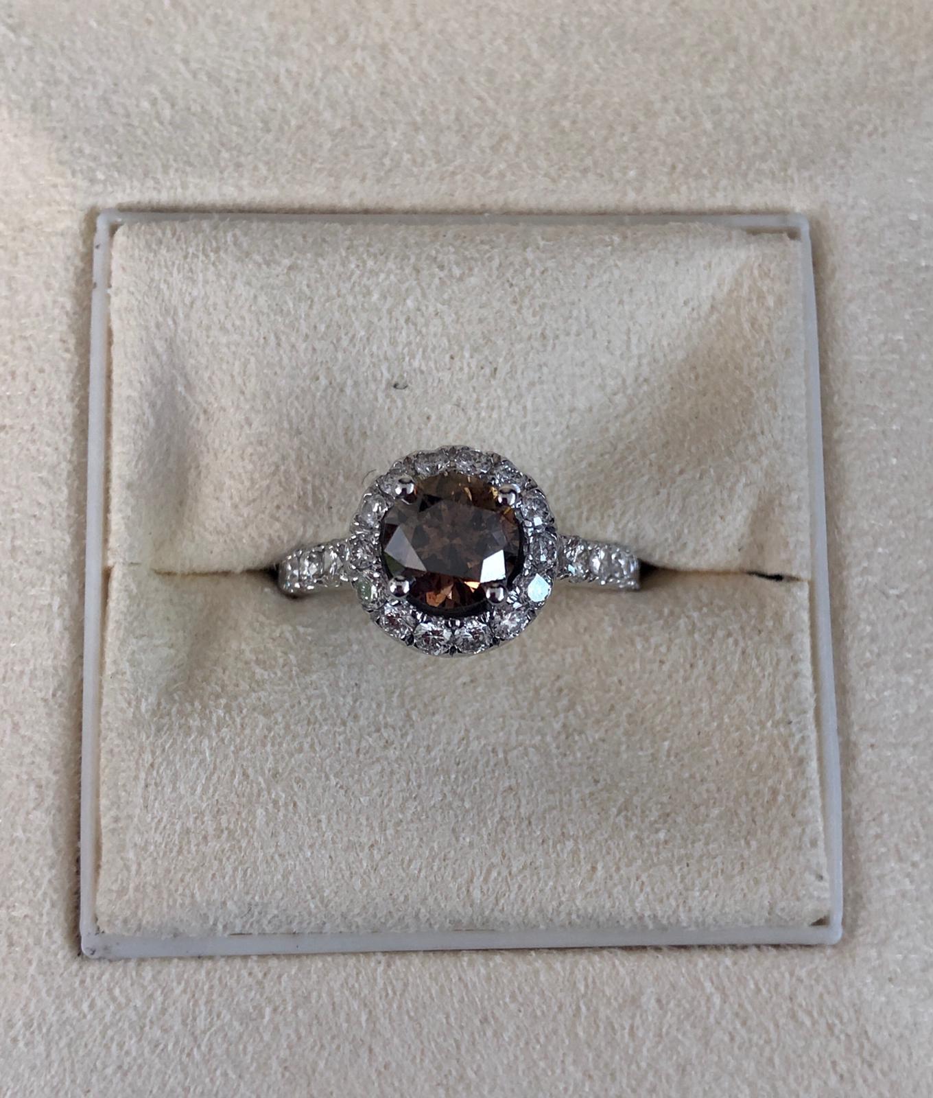 Fancy Dark Brown-Greenish Yellow natural round diamond weighing 2.50 carats by GIA.  Half way paved white diamonds in the halo setting. Its transparency and luster are excellent. set on 18K white gold, this ring is the ultimate gift for