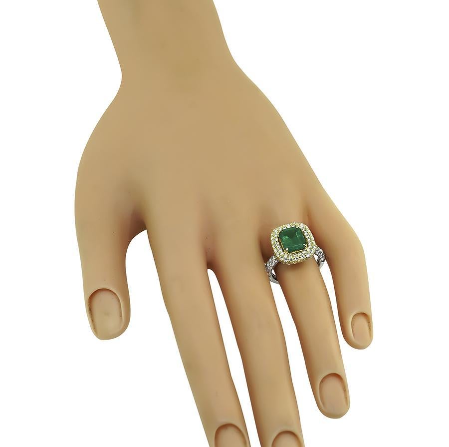 Este es un precioso anillo de compromiso de oro amarillo y blanco de 18 quilates. El anillo está centrado con una preciosa esmeralda colombiana de talla esmeralda certificada por el GIA que pesa 2.51 ct. La piedra central está realzada por