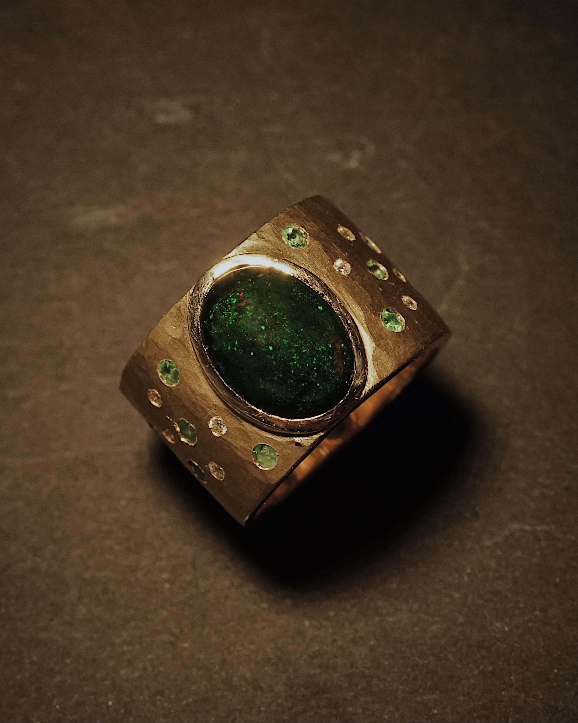 Schöne zertifizierte natürliche Black Opal Cluster Ring.
Das Zentrum des aus 18 Karat Gold gefertigten Schmuckstücks ziert ein GIA-zertifizierter, natürlicher und unbehandelter schwarzer Opal von 2,62 Karat im ovalen Doppel-Cabochon-Schliff. Die