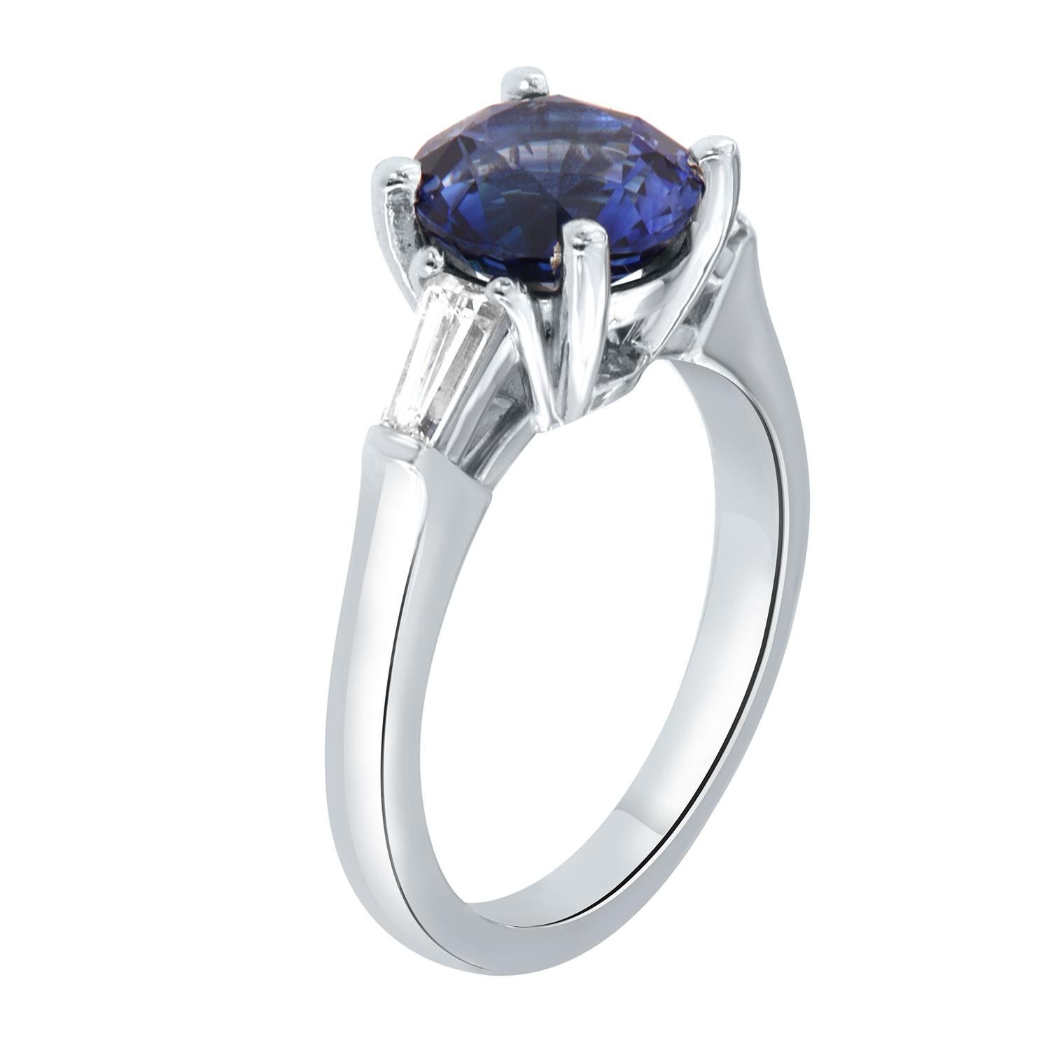 This classic platinum ring features a 2.65 Carat Oval shape Vivid Blue Natural Sapphire flanked by two(2) Baguette-shaped diamonds in a total weight of 0.40 Carat on a 2.4 mm wide band. 
The Sapphire exhibits vibrant blue color in an excellent