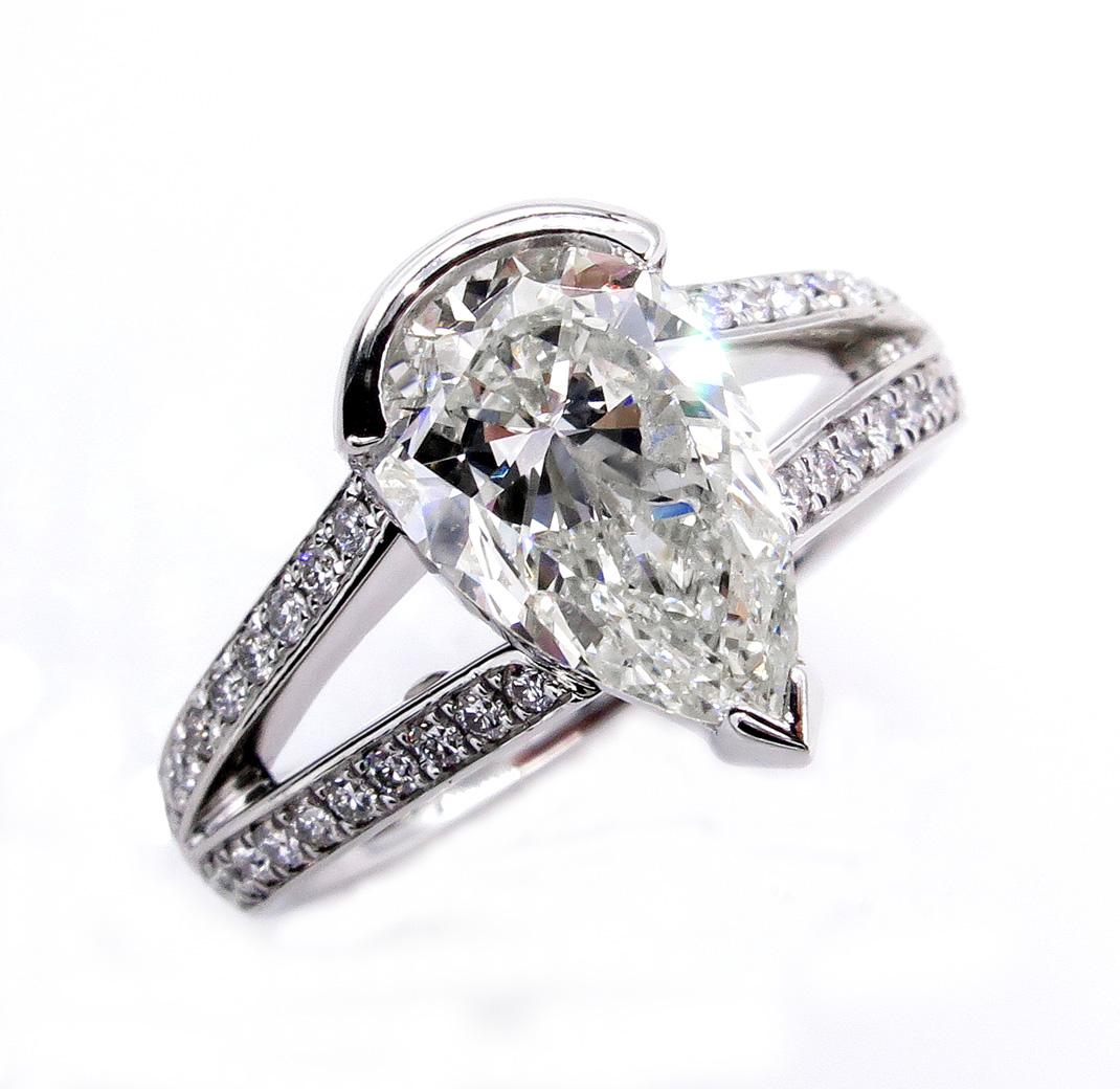 SUPER Elegant Timeless Pave Diamond PEAR Diamond Ring from our Estate Collection.
The Center diamond is almost 2.0ct (1.72ct) K color, SI2 clarity GIA CERTIFIED. GREAT CUT and AMAZING BRILLIANCE!
The Diamond faces up very nice- warm White, Bright