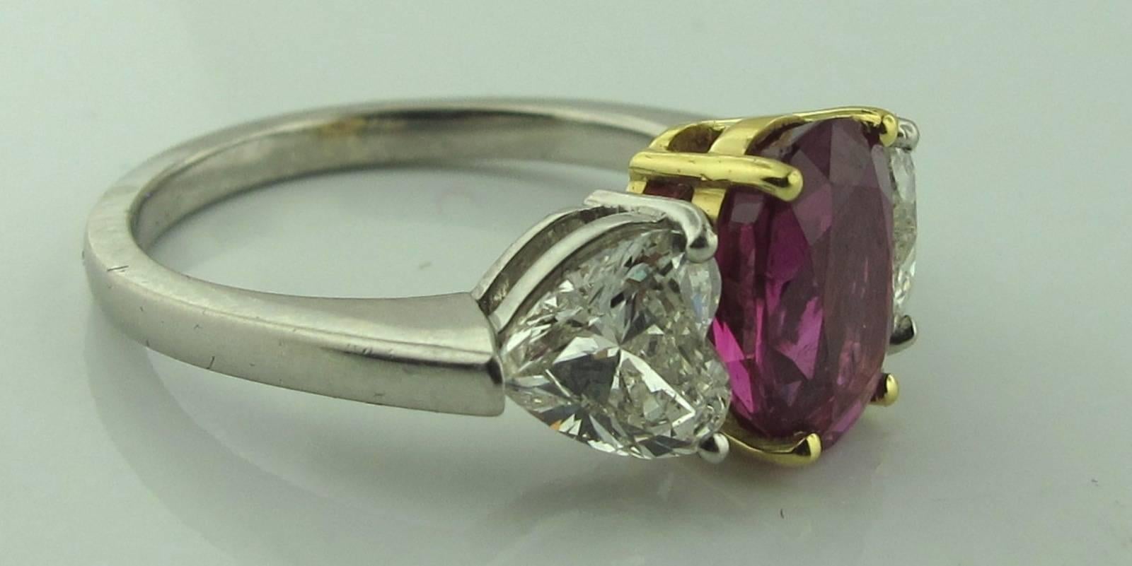 GIA Certified 2.81 carat Oval Ruby set in Yellow Gold, with two heart shaped diamonds on either side with a total diamond weight of 1.63 carats set in platinum.  I color, VS-2 clarity. The ruby is accompanied by a GIA certificate BURMA UNHEATED.  