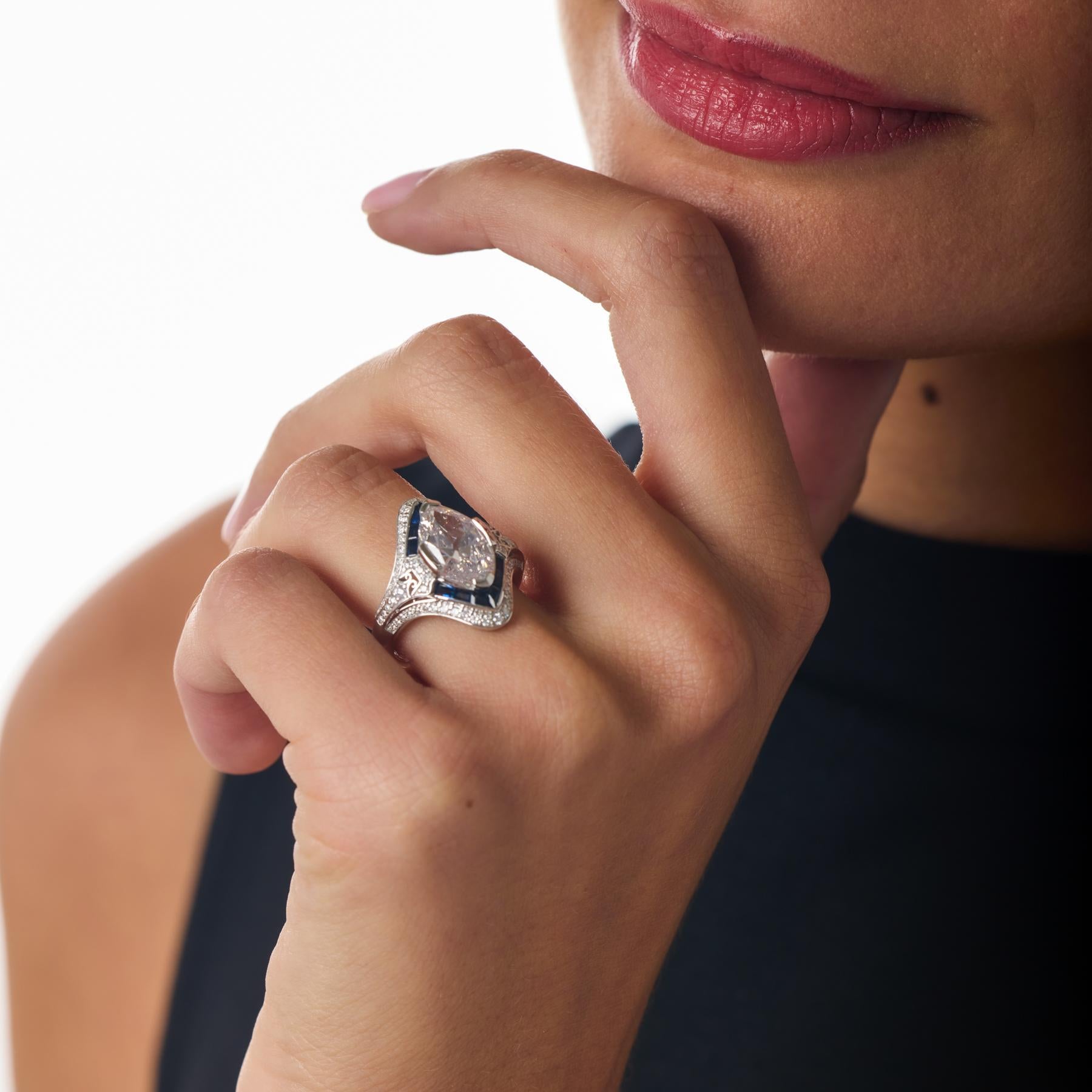 Cette bague de fiançailles moderne rayonne d'une élégance frappante avec son rare diamant Marquise Old Mine Cut, une pierre centrale spectaculaire qui allie le charme antique à l'allure contemporaine. Un cadre chatoyant de diamants ronds et