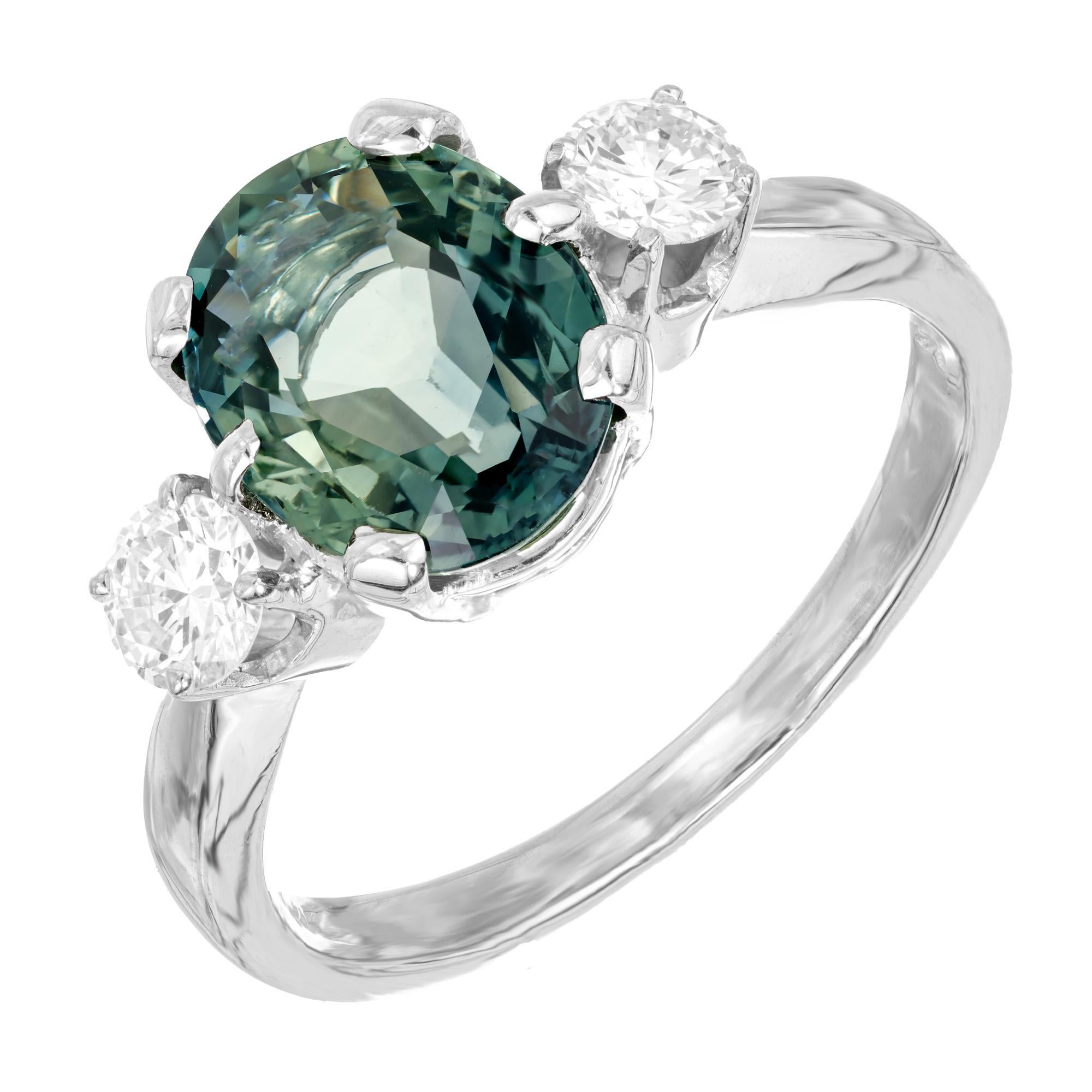 A minty blue green sapphire and diamond engagement ring. GIA certified oval 2.96ct blue green sapphire center stone. Set in a three-stone 14k white gold setting with two round brilliant cut side diamonds. This sapphire has been certified by the GIA