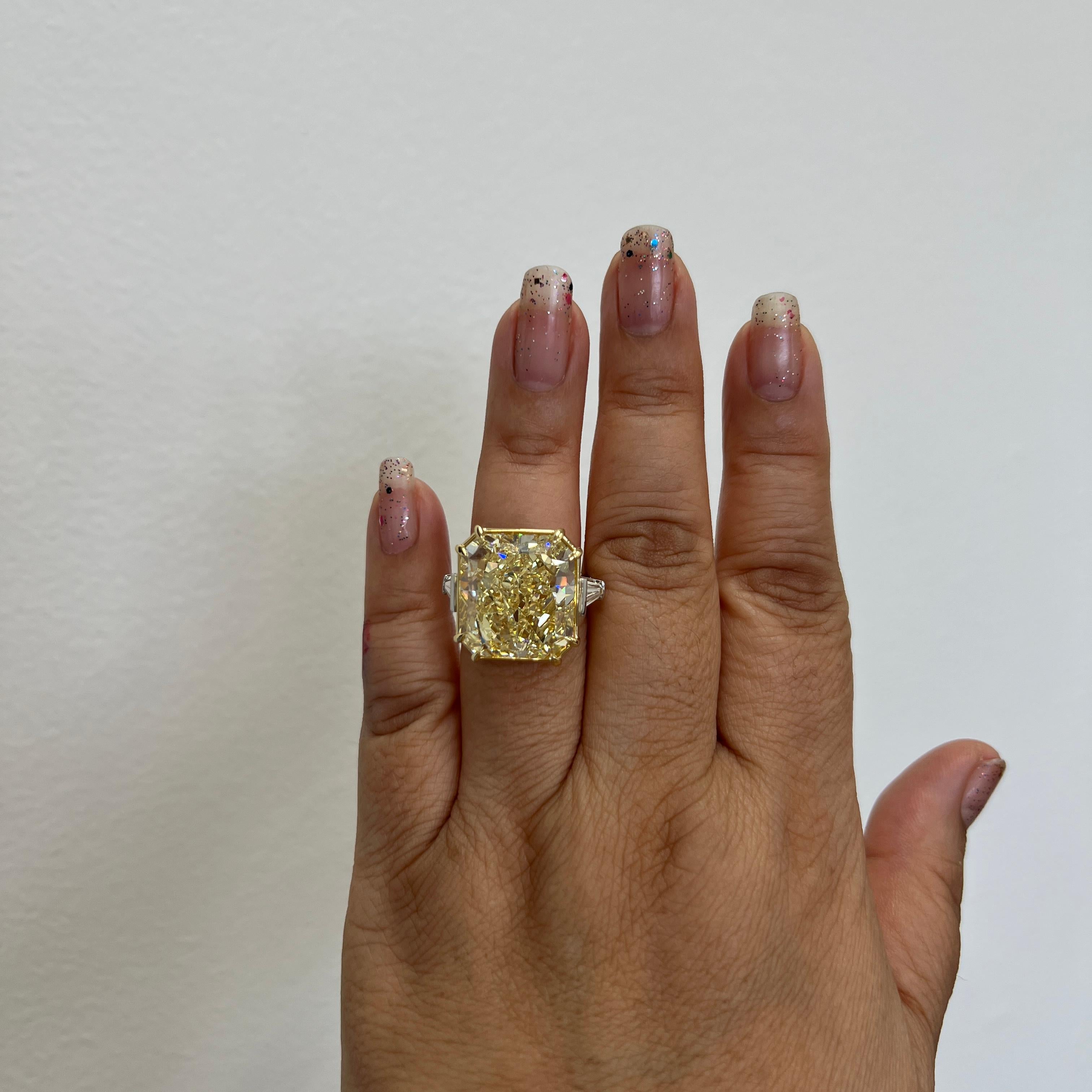 Absolutely mind blowing 30.91 ct. fancy yellow VS2 radiant diamond with two good quality, white, and bright white diamond baguettes.  Handmade in 18k yellow gold and platinum.  Ring size 6.5.  GIA certificate included.