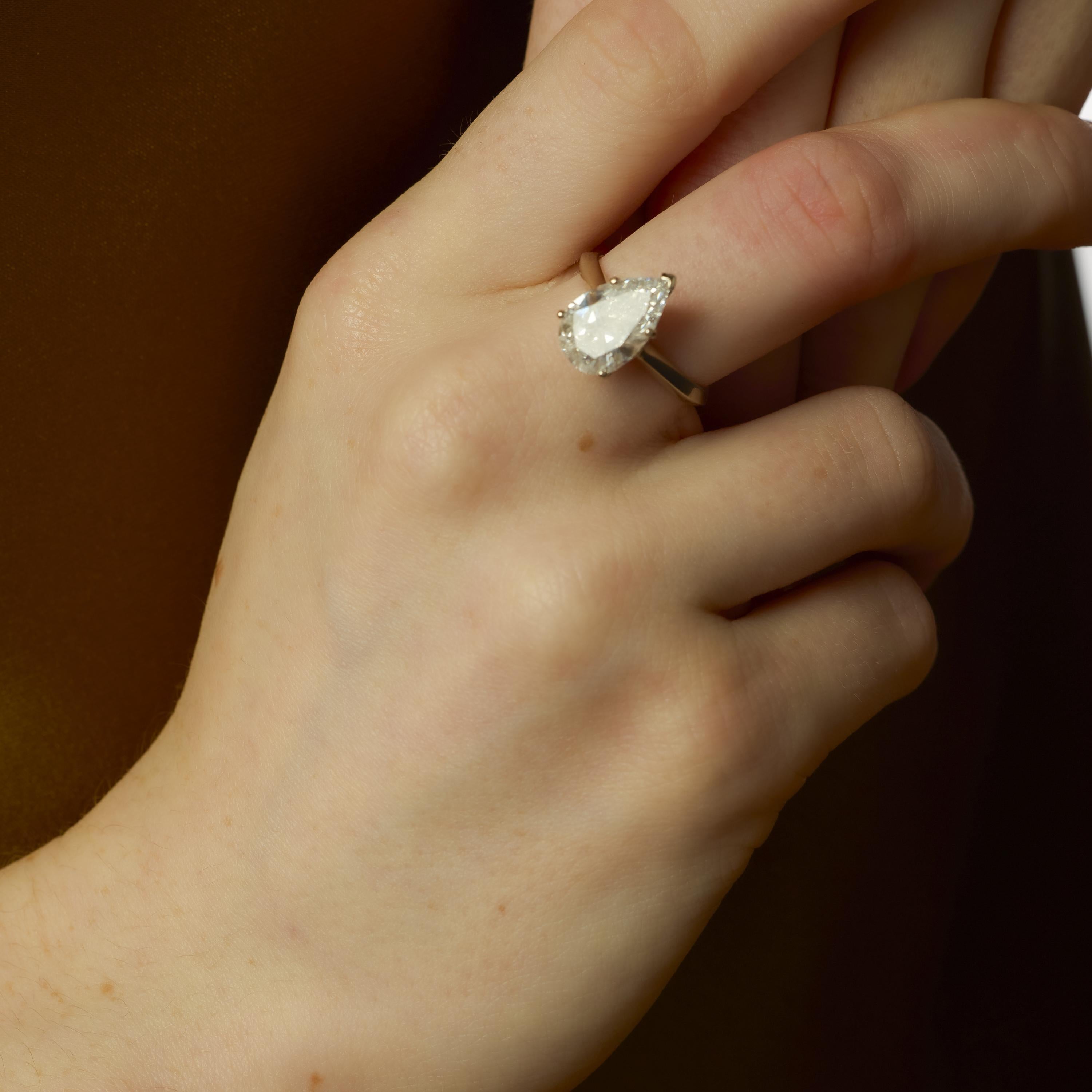 Cette bague vintage met en valeur un superbe diamant poire de 3,00 carats, certifié par le GIA (#2233585128), d'une couleur D exceptionnelle et d'une présence captivante. Sertie dans de l'or blanc 14k poli, la forme et la taille de la pierre créent
