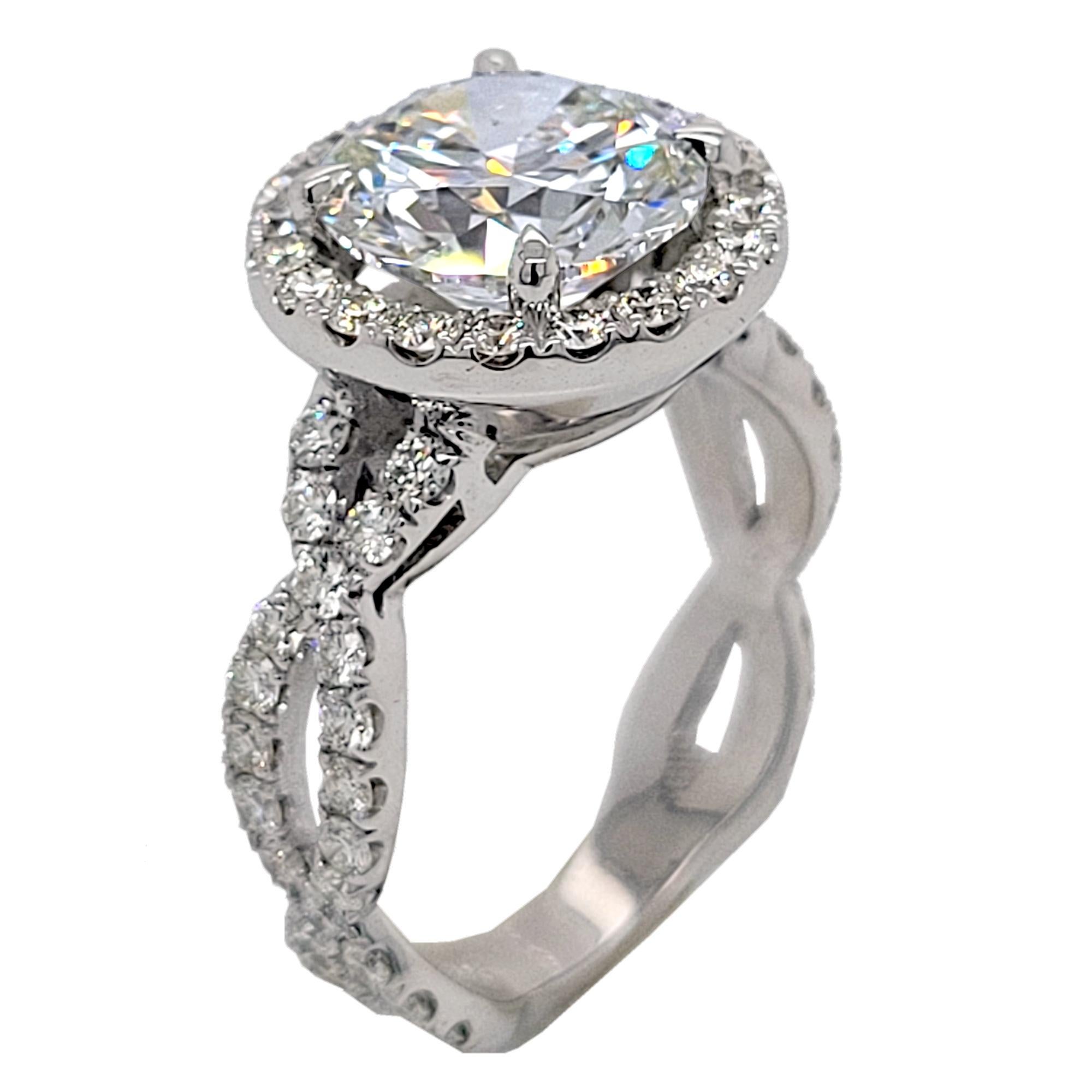 Un magnifique diamant rond brillant J/VS2 certifié par la GIA serti au centre du  Une magnifique bague de fiançailles en diamant 18K avec halo, sertie de pavés et torsadée sur la tige fendue. Poids total de 1,00 ct. de diamants sur le côté.