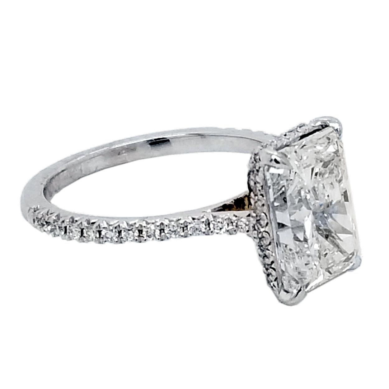 A very fine Radiant D/SI2 GIA certified Diamond set in a fine 18k gold French-Pave set Engagement Ring with side halo. Total diamond weight of 0.25 Ct. on the side. 

Diamond specs:
Center stone: 3.04 Ct GIA Certified D/SI2 Radiant natural