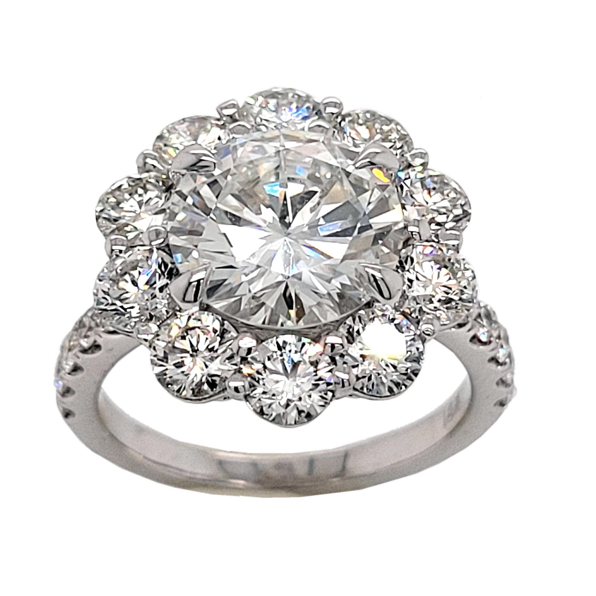 A beautiful GIA Certified Round Brilliant F/VVS2 center Diamond set in a Gorgeous 18K Diamond Engagement Ring with larger stone Halo and side diamonds on the side. Total diamond weight of 2.49 Ct. diamonds on the side. 

Diamond specs:
Center stone: