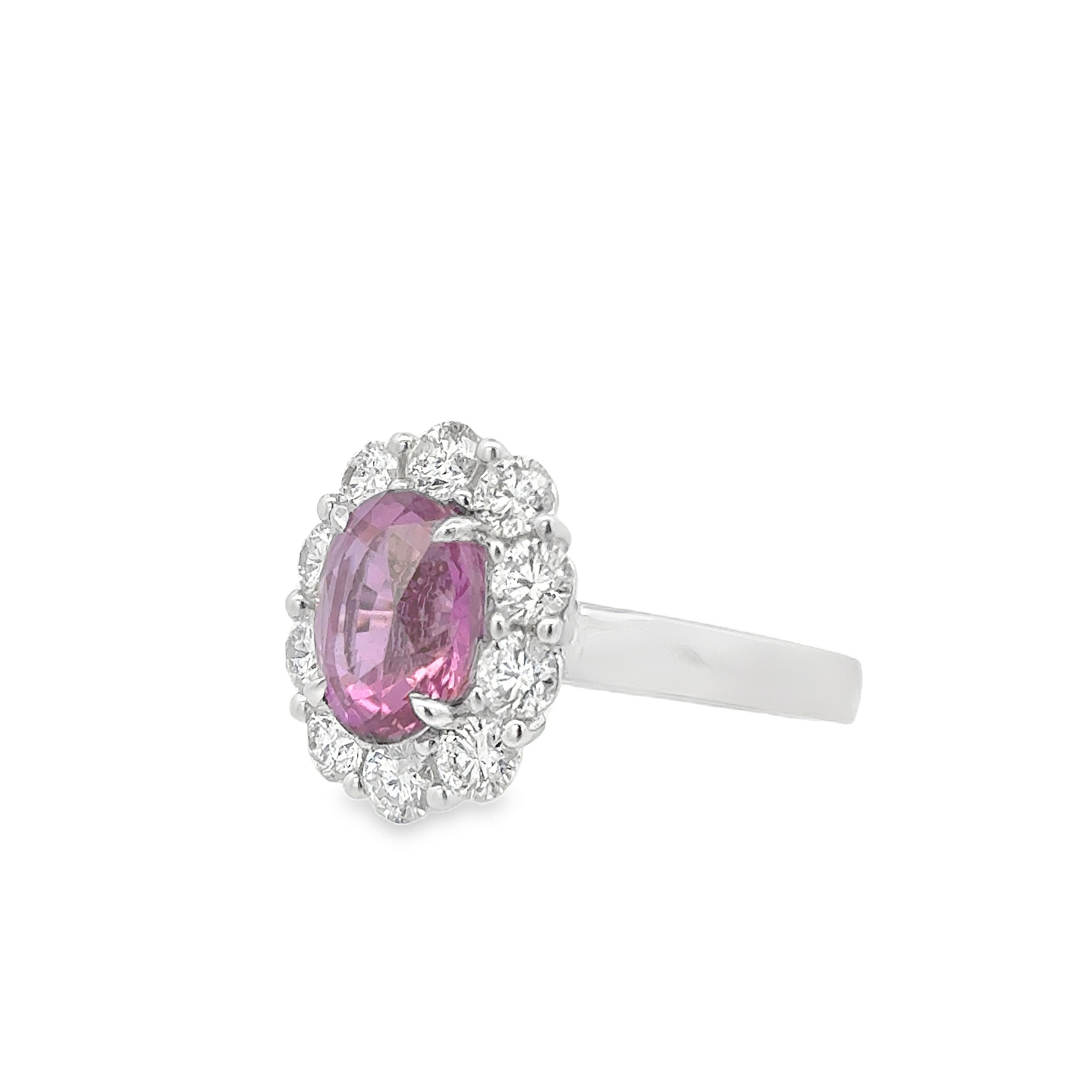 A lovely engagement ring, featuring a 3.20 carats oval cut sapphire certified by GIA as natural with purplish pink color and no indications of heat treatment. Accented by a halo of 10 round brilliant cut diamonds weighing 1.20 carats total, set on a