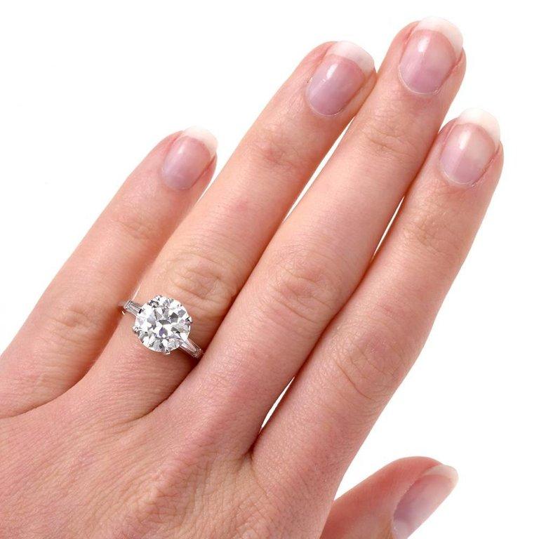 Classic Diamond Engagement ring is crafted in solid platinum, weighing approx: 5.0 grams with center diamond Weiging 3.21 carats, H-color, SI1 clarity set in prong set and two tapper baguette cut diamonds approx: 0.40 carats, G-H color, VS clarity.