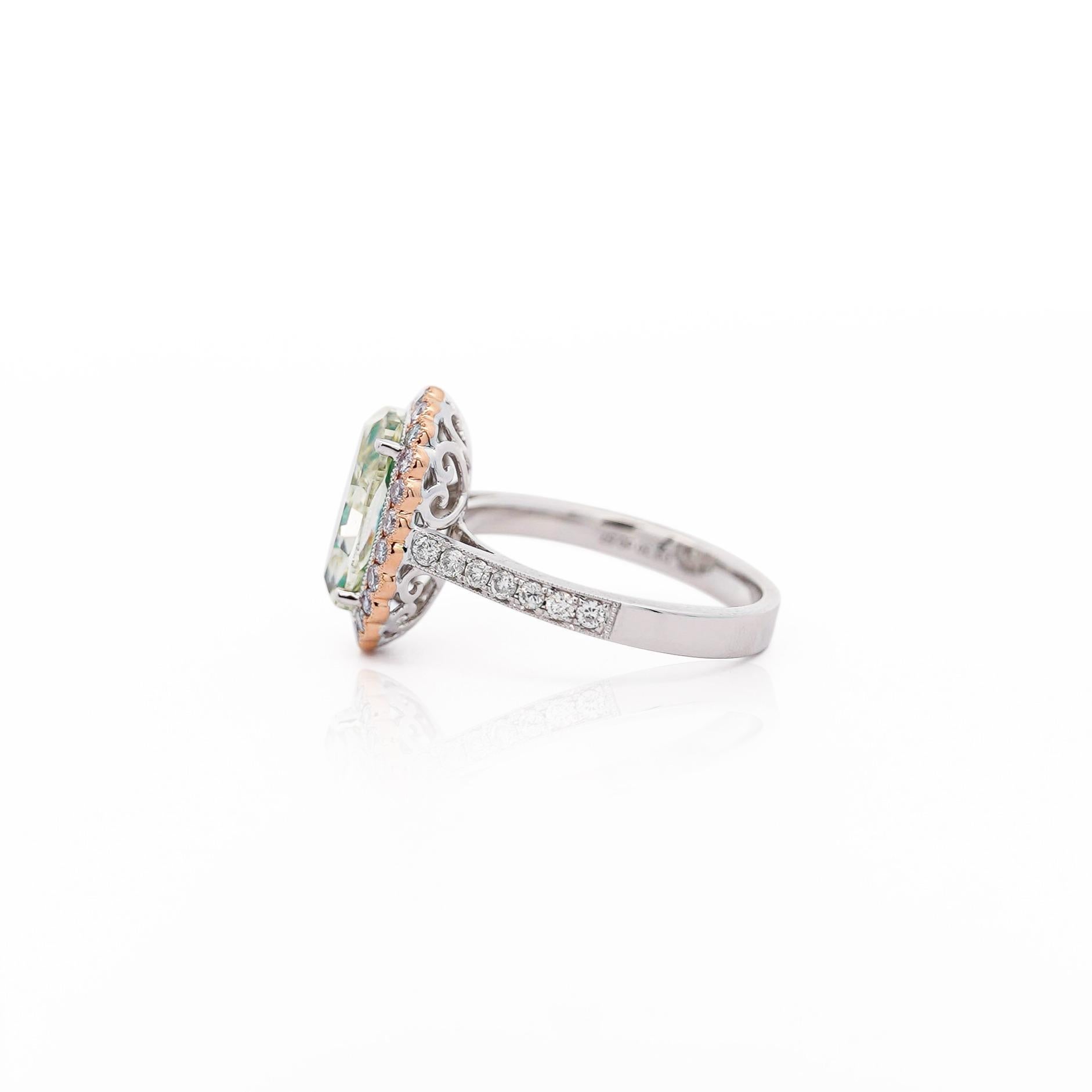 En este exquisito anillo de oro blanco y rosa de 18 quilates, rodeado de un radiante halo de diamantes rosas y una caña con pavé de diamantes blancos, un diamante natural de talla ovalada de 3,30 quilates de color amarillo verdoso de fantasía ocupa