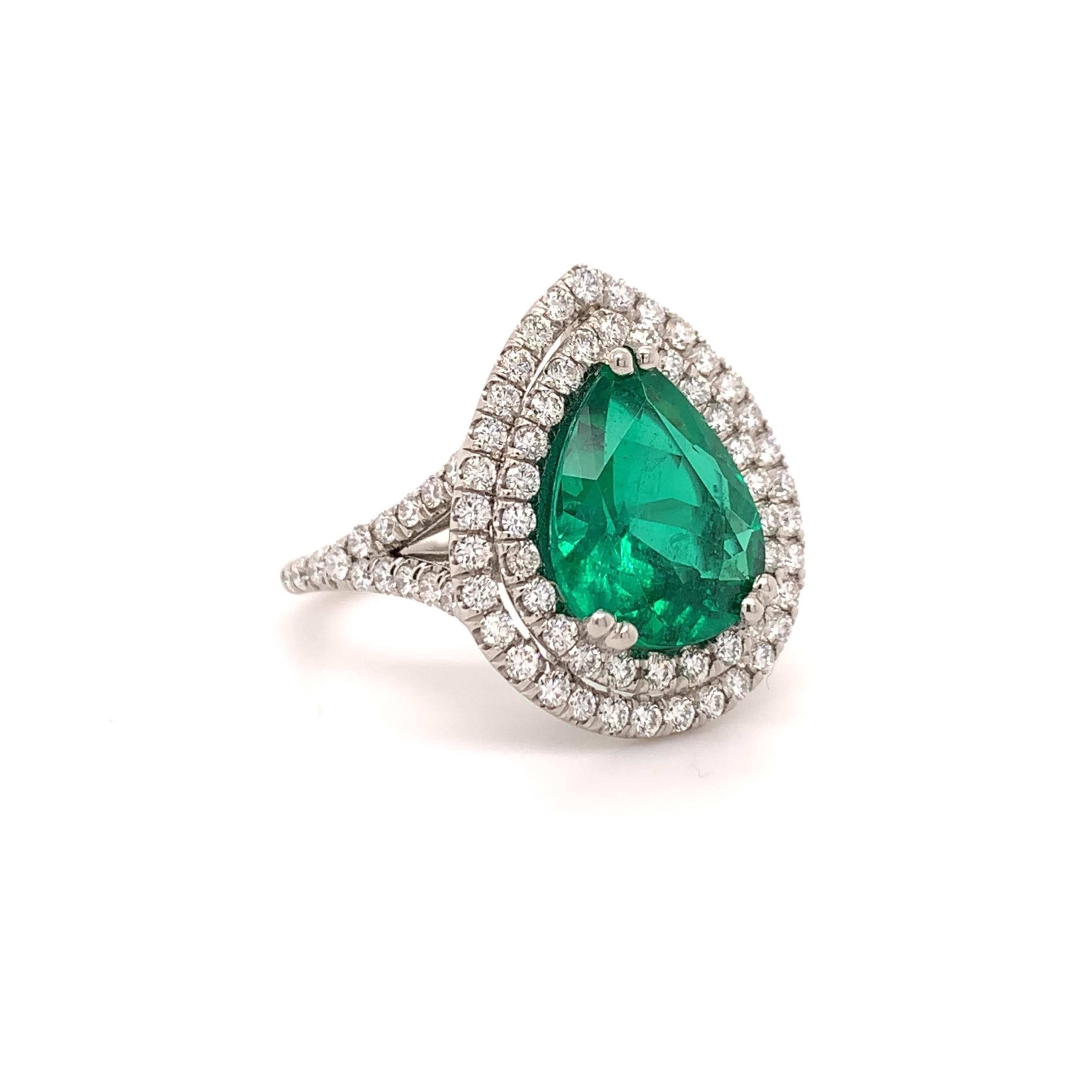 Glamorous emerald cocktail ring. High brilliance, intense green tone, pear faceted, transparent, Zambian origin, natural 3.37 carats emerald encased in an open mount with six bead prongs, accented with two round brilliant cut diamonds. Handcrafted