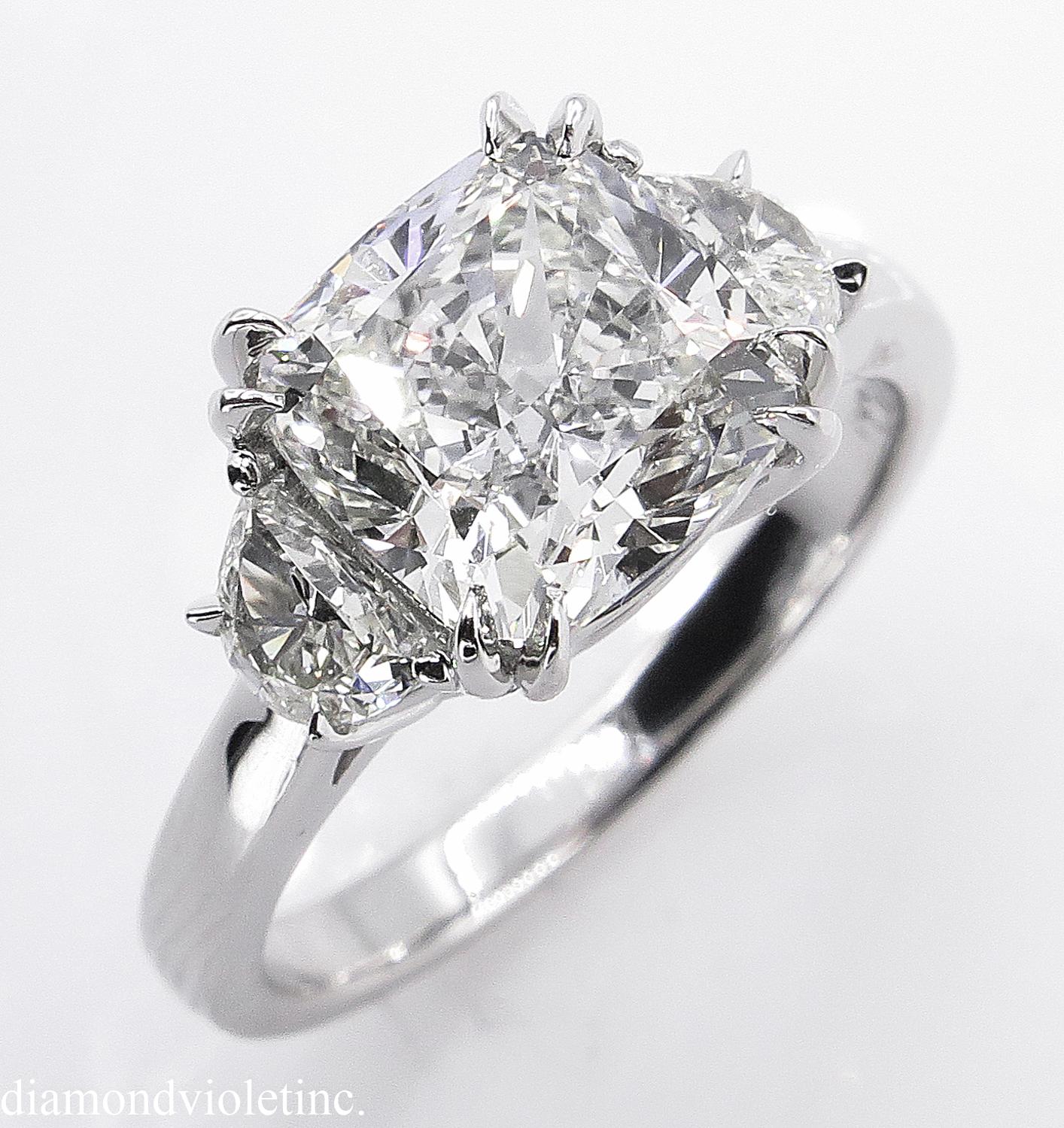 A Breathtaking vintage HANDMADE PLATINUM (stamped) Cushion Diamond Three-Stone Engagement ring. The Prong Set Cushion Diamond is estimated 3.01CT with measurements of 7.97x7.97x5.45mm. GIA Certified in K color and VS2 clarity (Appears Warm White and