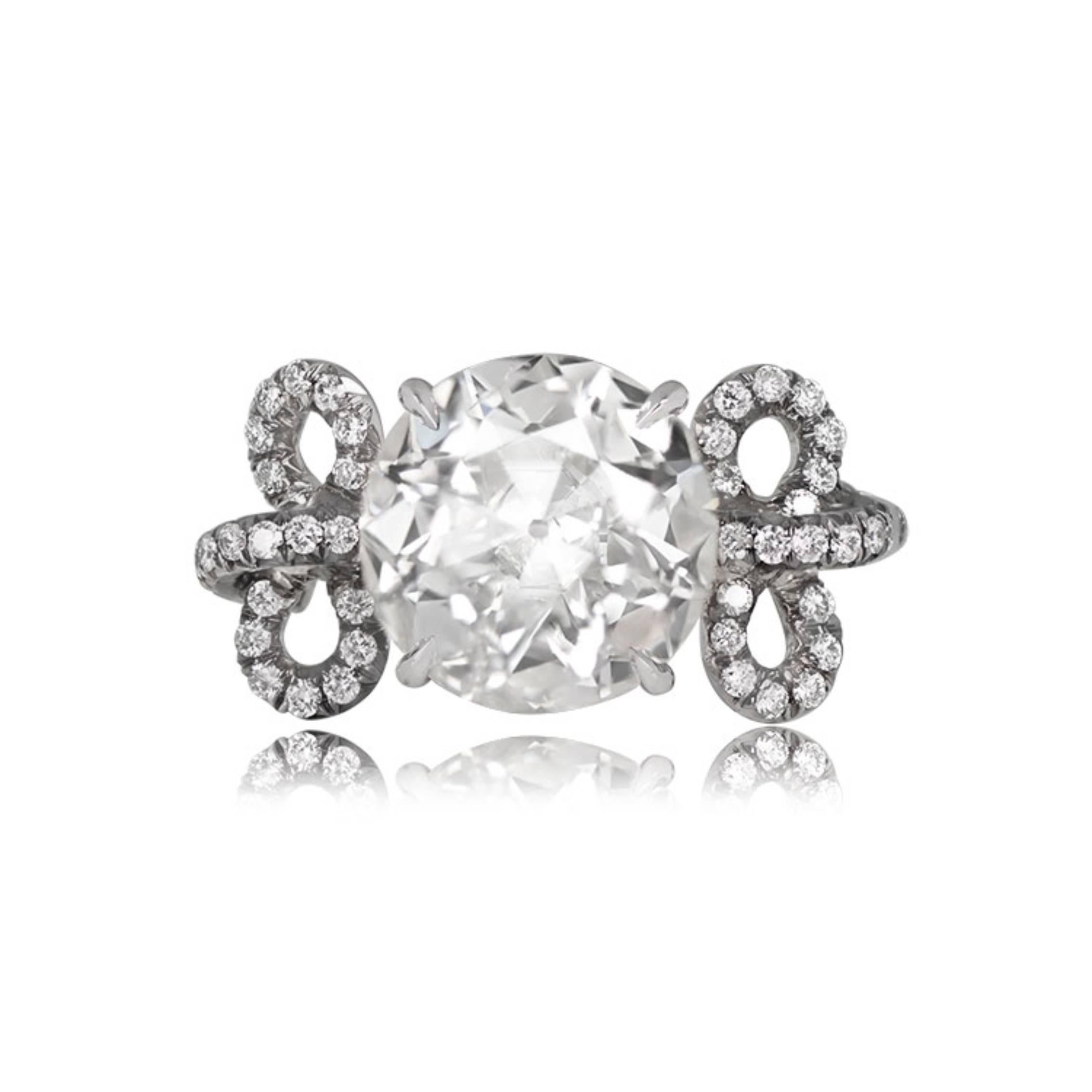 This platinum ring showcases a striking GIA-certified 3.43-carat old European cut diamond with I color and SI2 clarity, prong-set. The shoulders are adorned with smaller round brilliant diamonds in a micro-pave setting in a bow motif.


Ring Size: