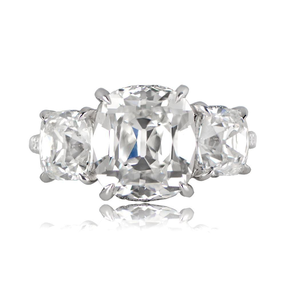 A stunning platinum three-stone ring with a vibrant GIA-certified antique cushion-cut diamond at the center, weighing 3.53 carats, with G color and VS1 clarity. This exquisite ring is complemented by two antique cushion-cut diamonds flanking the