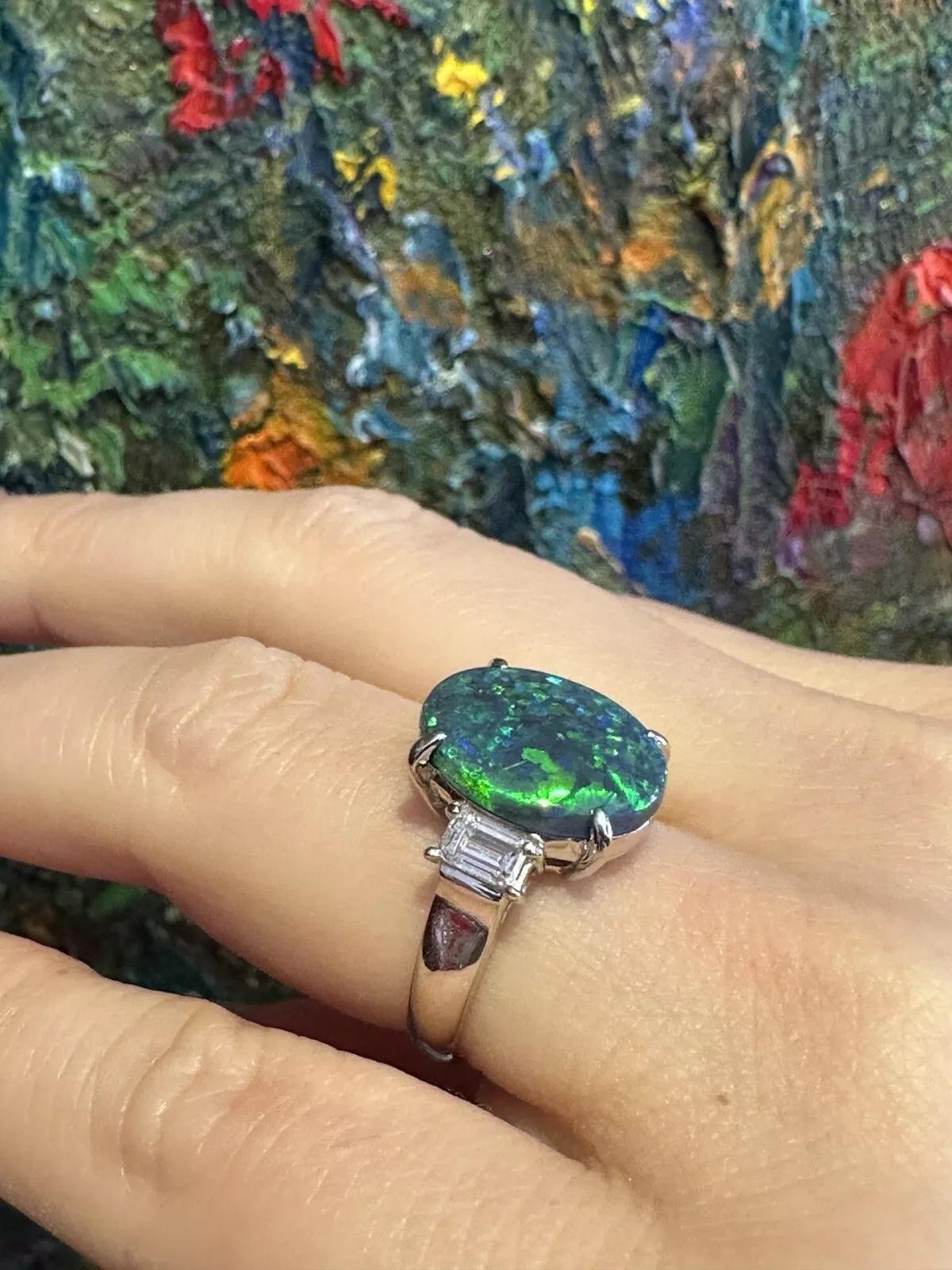 GIA Certified 3.59 carat Black Opal and Diamond 3-stone Ring in Platinum 

Black Opal and Diamond Ring features an oval-shaped GIA certified Black Opal with Blue and Green play of color accented by two rectangular Baguette Diamonds, all set in