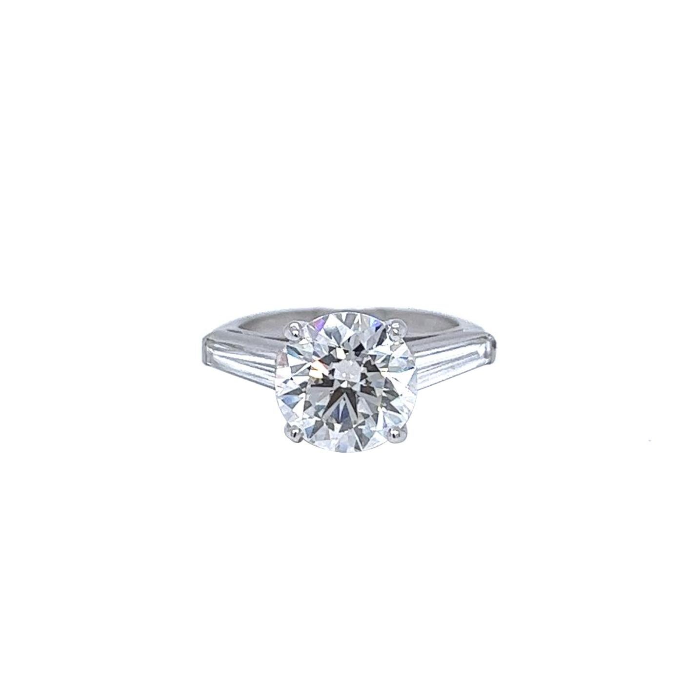 Setzen Sie ein Zeichen mit diesem atemberaubenden Ring, der mit einem runden Diamanten von 3,61 Karat J/VS1 besetzt ist. Der Ring ist außerdem mit 1.15 Karat Diamanten in Baguetteform besetzt, die für noch mehr Glanz und Funkeln sorgen. Der Ring
