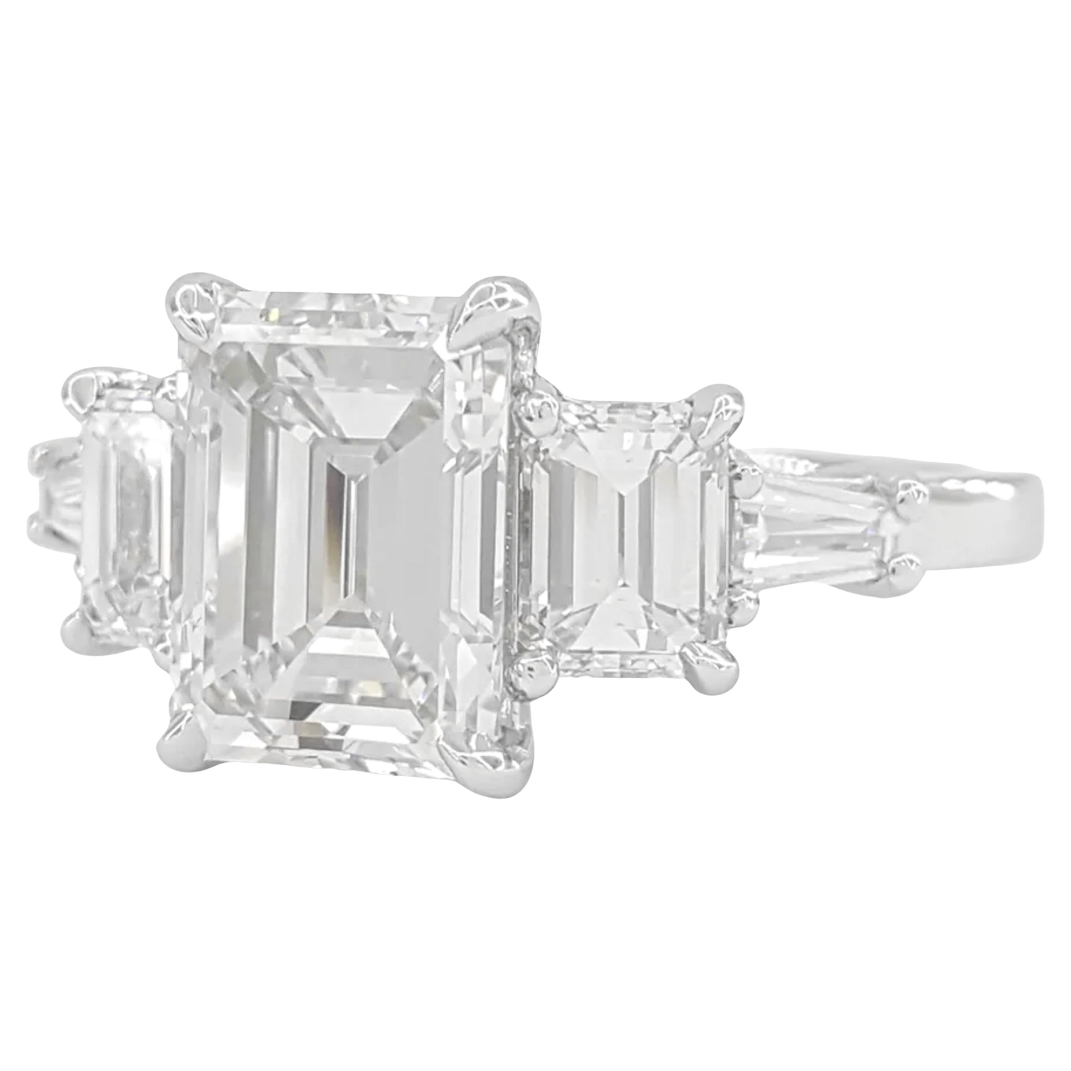 stunning engagement ring features a total weight of 3.8 ct and showcases a beautiful combination of an emerald cut diamond and emerald accents.

The centerpiece is a natural ideal emerald cut diamond weighing 2.56 ct, with an E color grade and VS2