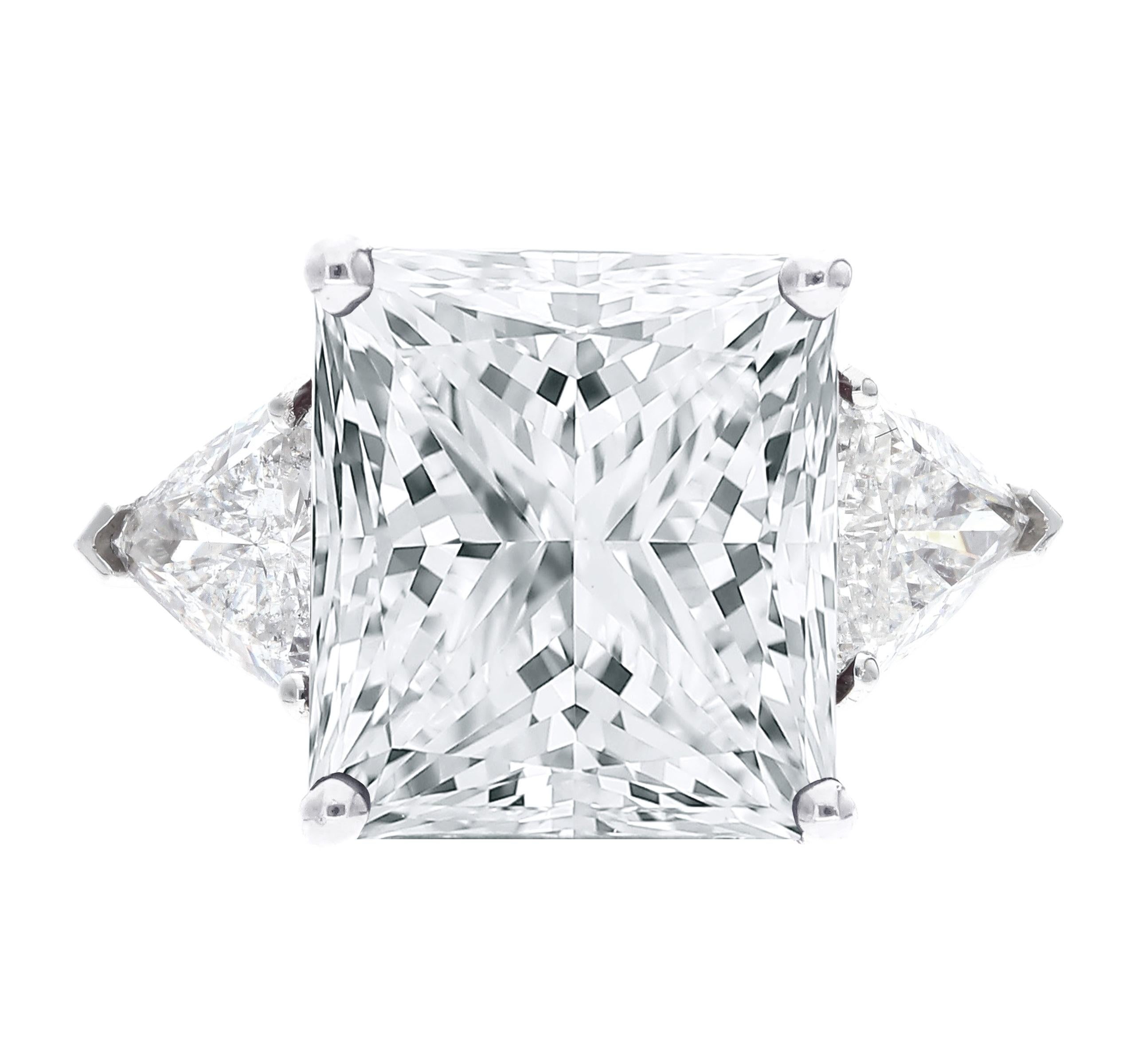 Cette superbe bague présente en son centre un magnifique diamant taille princesse de 4 carats, qui respire l'élégance et la sophistication. Flanqués de part et d'autre, deux exquis diamants de taille trillion ajoutent une allure unique et captivante