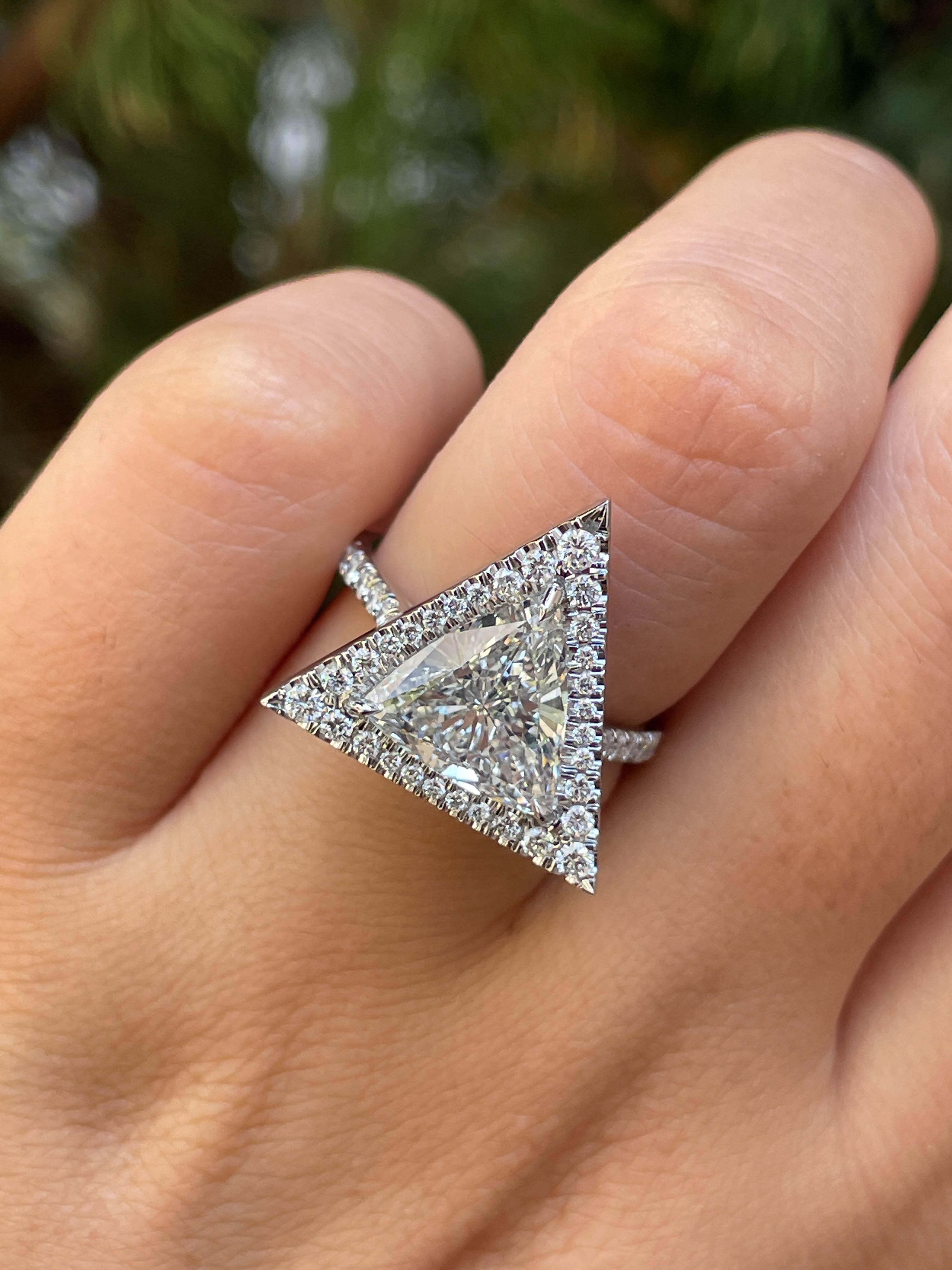 A Magnificent Estate Diamond Engagement Ring dazzles GIA certified 2.75ct Trillion shaped Center Diamond in L color VS2 clarity (Very clear); with measurements of 10.42x10.57x4.53mm. GIA report # 2151856625.
It is set into Micro Pave cut out Halo