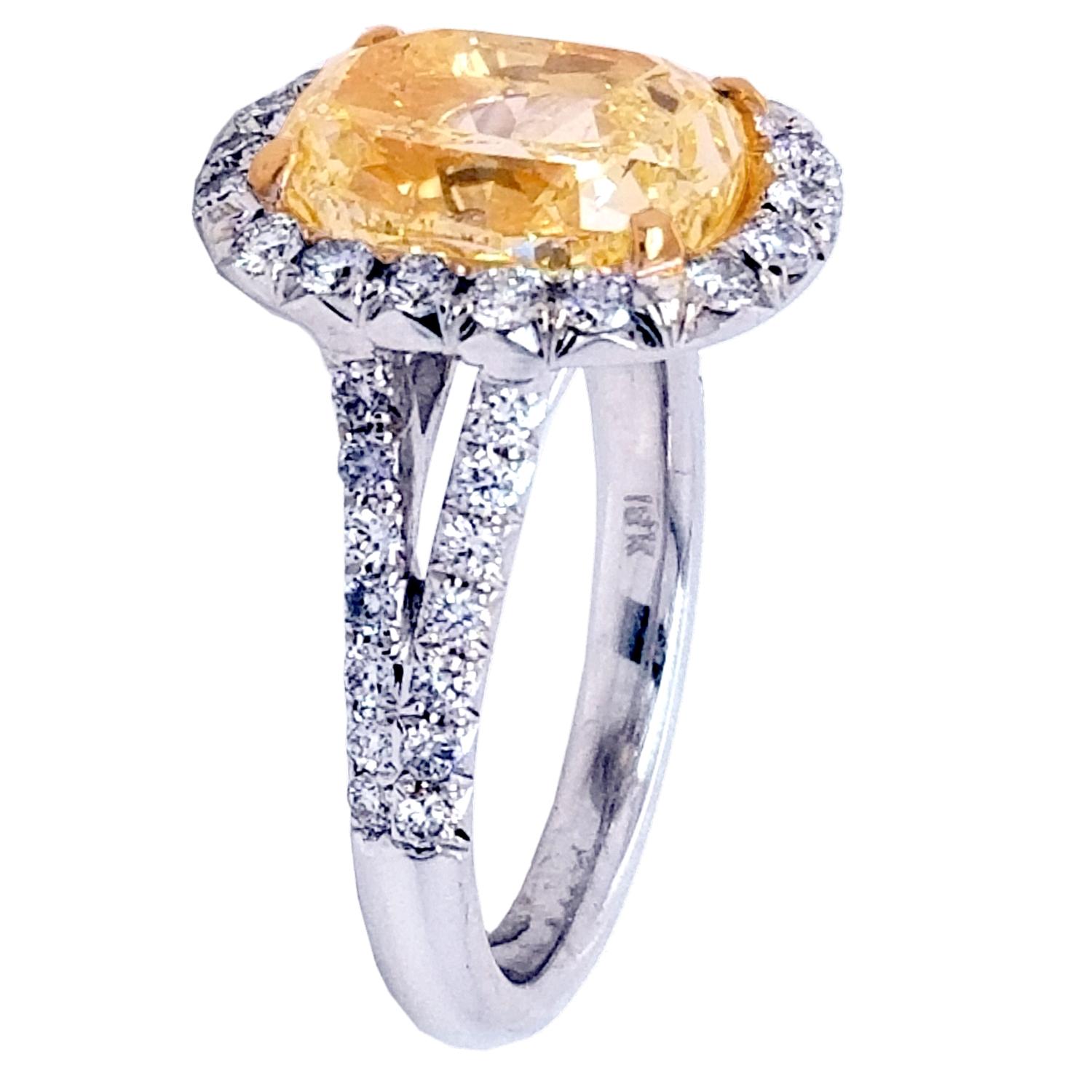 A Beautiful Oval Natural Fancy Yellow VS2 GIA certified center Diamond set in a fine 18k gold French Pave set Diamond Engagement Ring with halo. The ring has total weight of 0.75 Ct diamonds on the side. #sayitwithyellow #canarydiamond.

Center