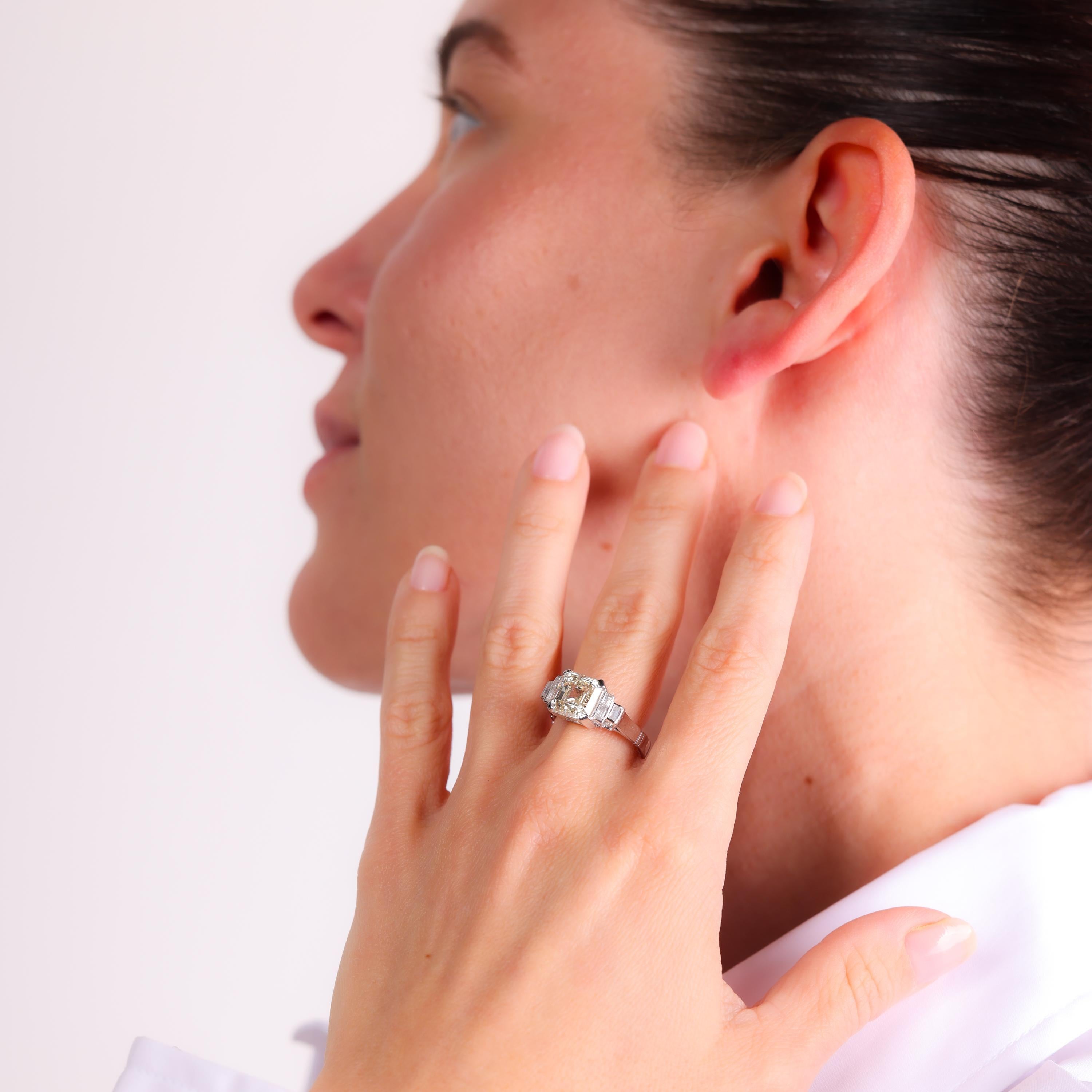 Dieser Verlobungsring aus 18 Karat Weißgold aus der Mitte des Jahrhunderts präsentiert einen atemberaubenden 4,05-Karat-Diamanten im Asscher-Schliff, der von Baguette-Diamanten flankiert wird, und bietet zeitlose Eleganz und Raffinesse aus den
