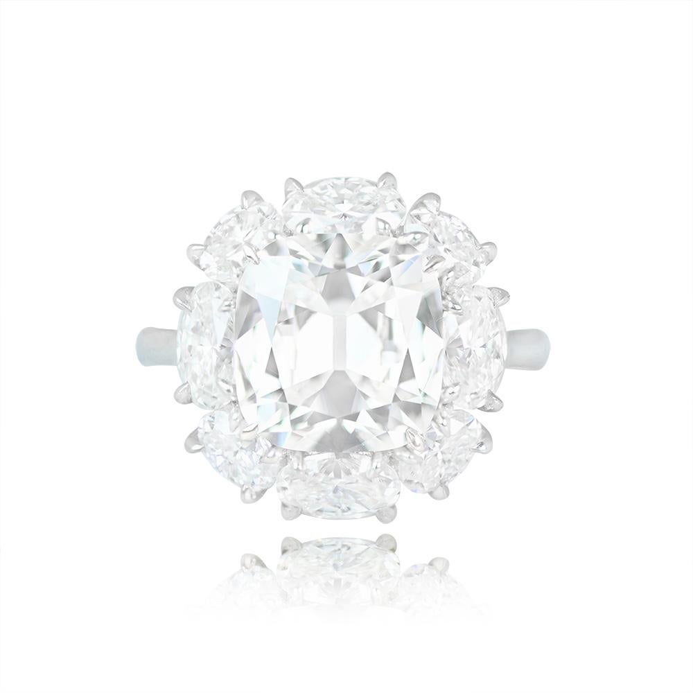 This exquisite cluster engagement ring showcases a GIA-certified 4.06-carat cushion-cut diamond with H color and VVS1 clarity. The central diamond is elegantly secured with prongs and encircled by a radiant halo of oval-cut diamonds. The combined