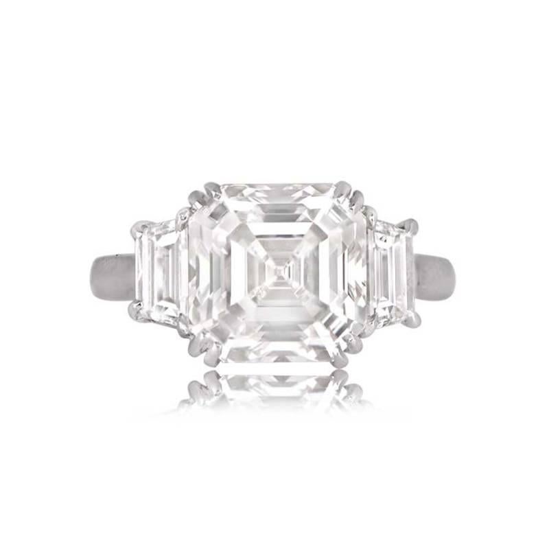 An impressive three-stone ring featuring a GIA-certified Asscher cut diamond weighing 4.20 carats, H color, and VVS2 clarity. The center diamond is flanked by two trapezoid diamonds with a combined weight of 1.16 carats, G-H color, and VS clarity.