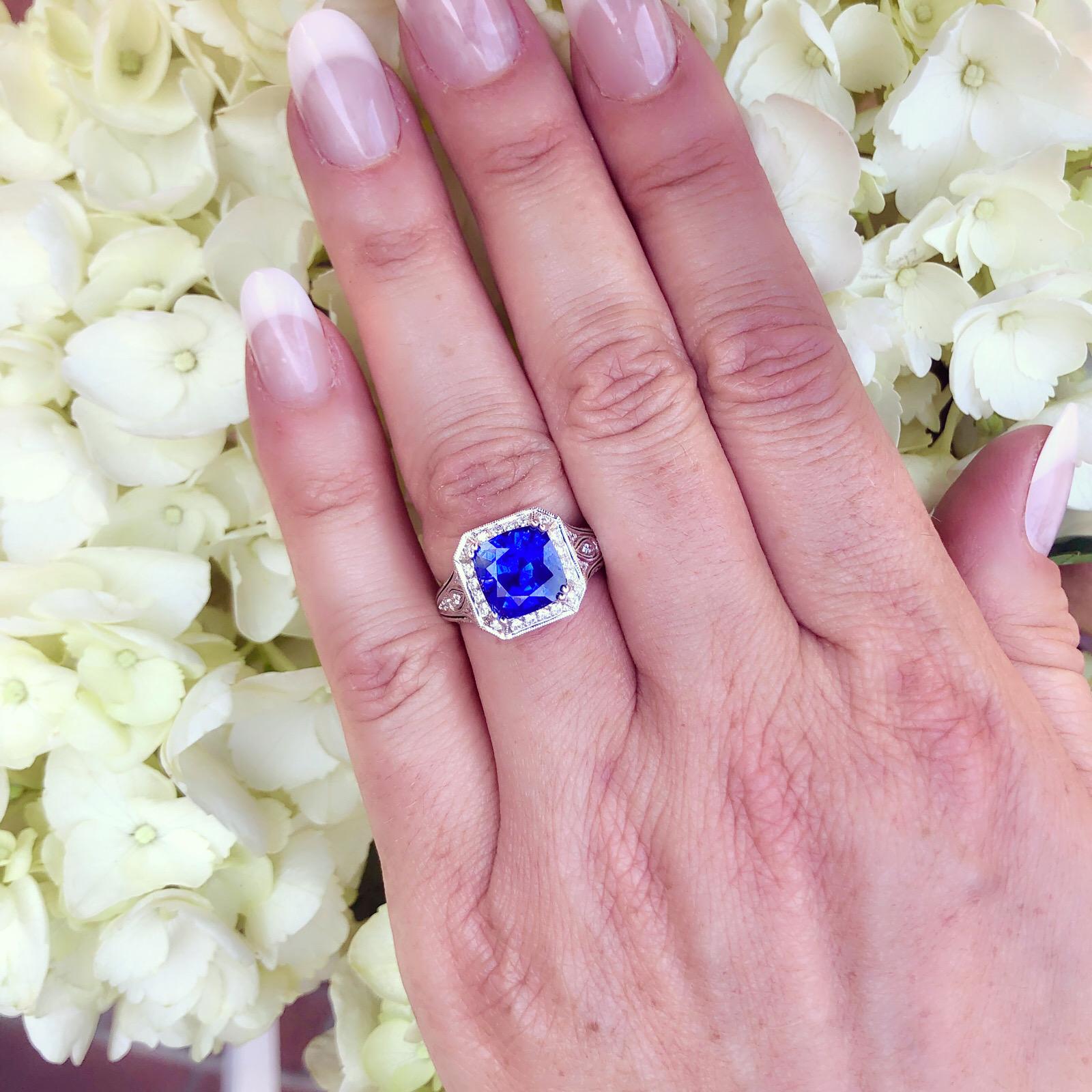 Magnifiquement détaillée, cette bague en or blanc 18 carats a l'élégance d'une époque révolue. Le saphir de 4,30 carats de taille coussin provenant du Sri Lanka, d'un bleu profond avec des nuances de violet, est mis en valeur sur une monture