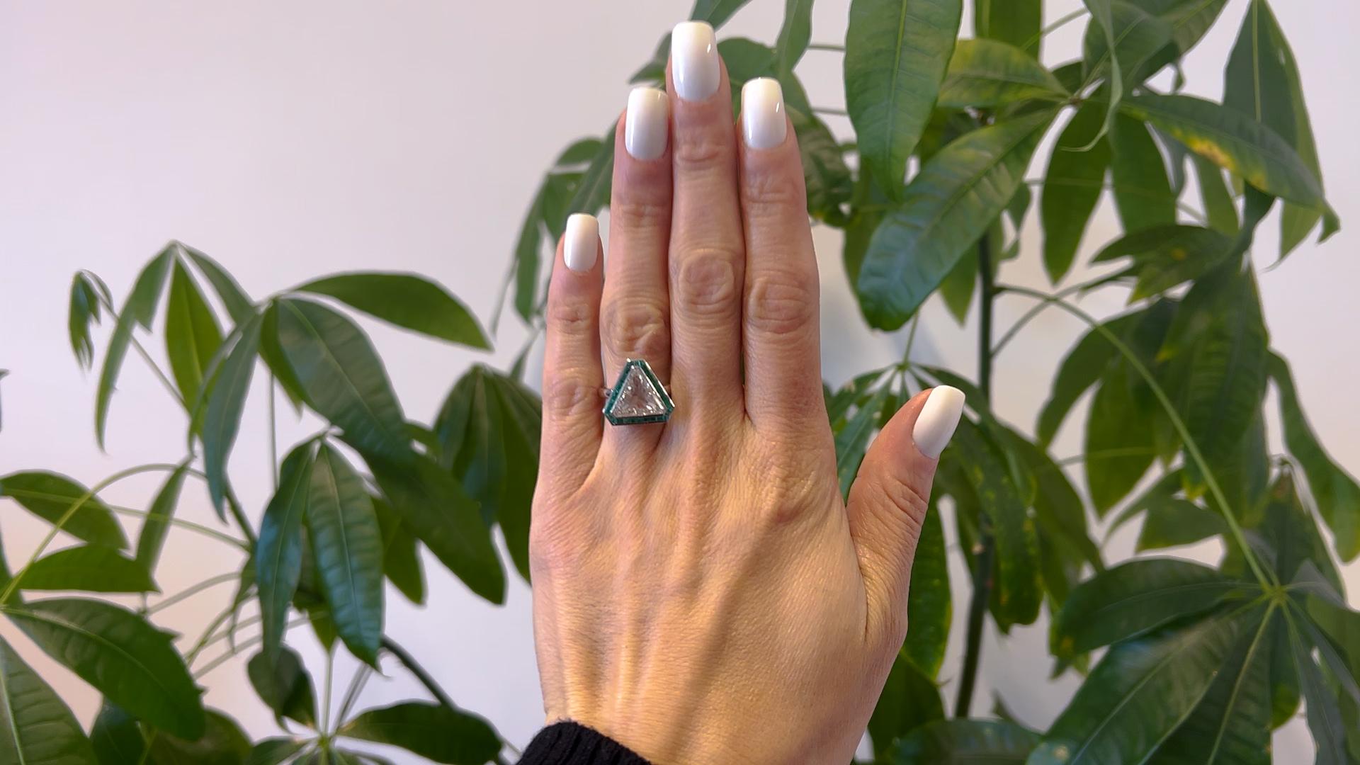 Ein GIA 4,40 Karat Dreiecksschliff Diamant und Smaragd Platin Ring. Mit einem GIA-Dreiecksschliff-Diamanten von 4,40 Karat, begleitet von GIA #2225678822, der angibt, dass der Diamant die Farbe L und die Reinheit SI2 hat. Akzentuiert durch 29