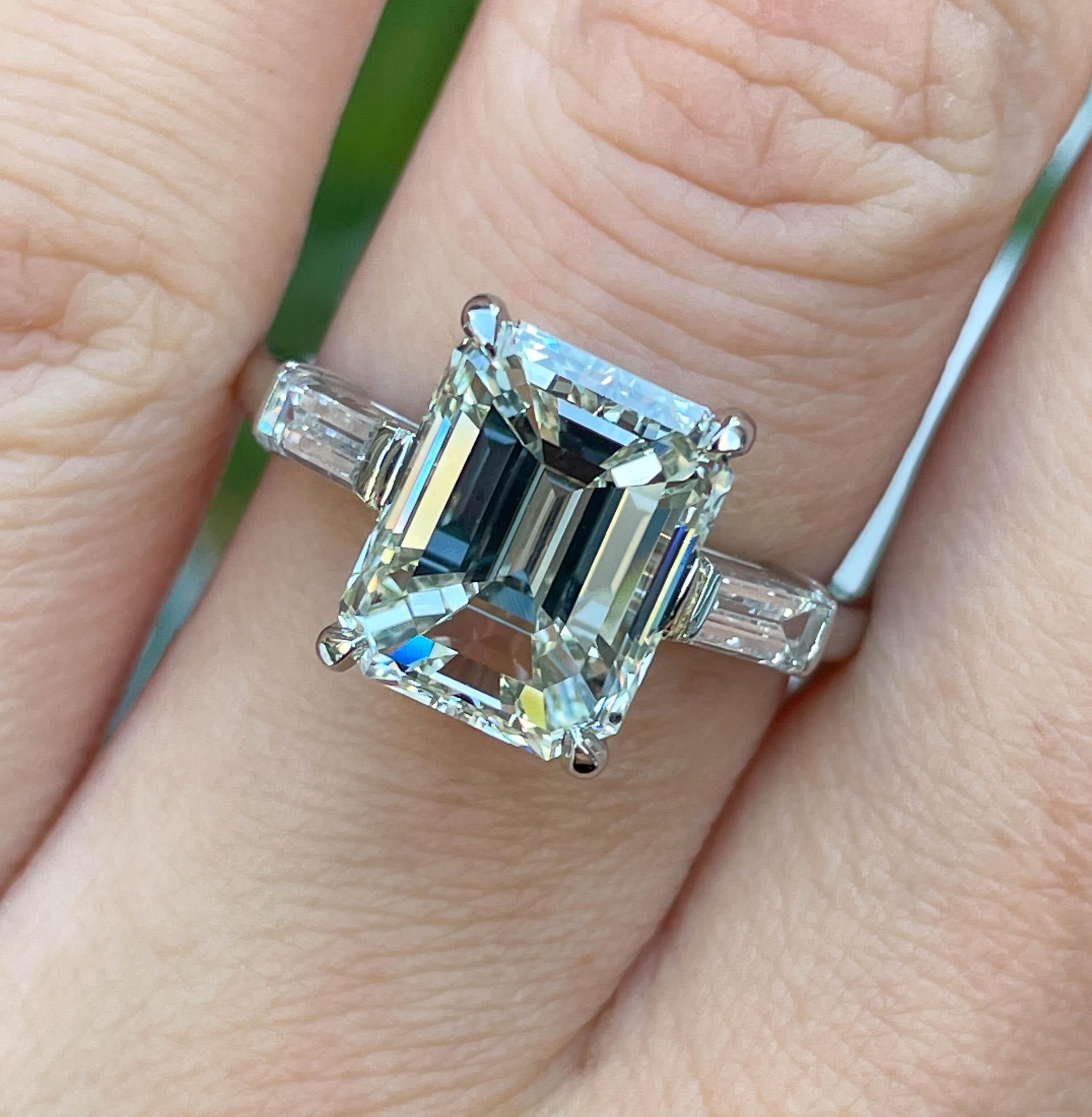 A Breathtaking Estate Vintage HANDMADE PLATINUM (stamped) Engagement ring dazzles GIA certified 4.02ct Emerald Diamond center diamond in K color SI1 clarity (Near COLORLESS and Eye clear); with measurements of 10.19x8.04x5.59mm. 
It is set with 2