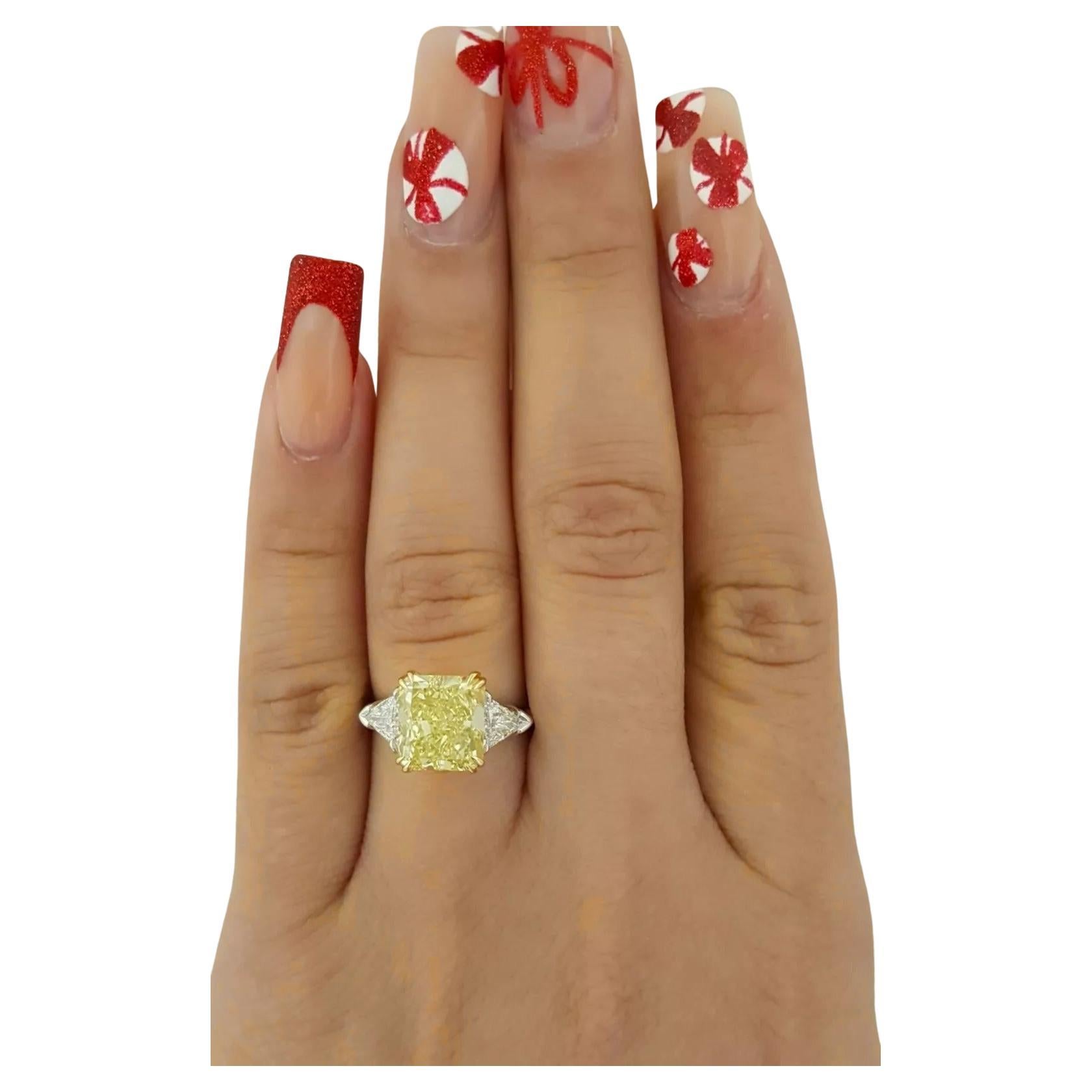 An exquisite engagement ring features a stunning 5-carat natural radiant cut diamond at its center, showcasing a captivating fancy yellow color and Flawless clarity. The diamond is recognized for its very good cut, with good polish and symmetry, and