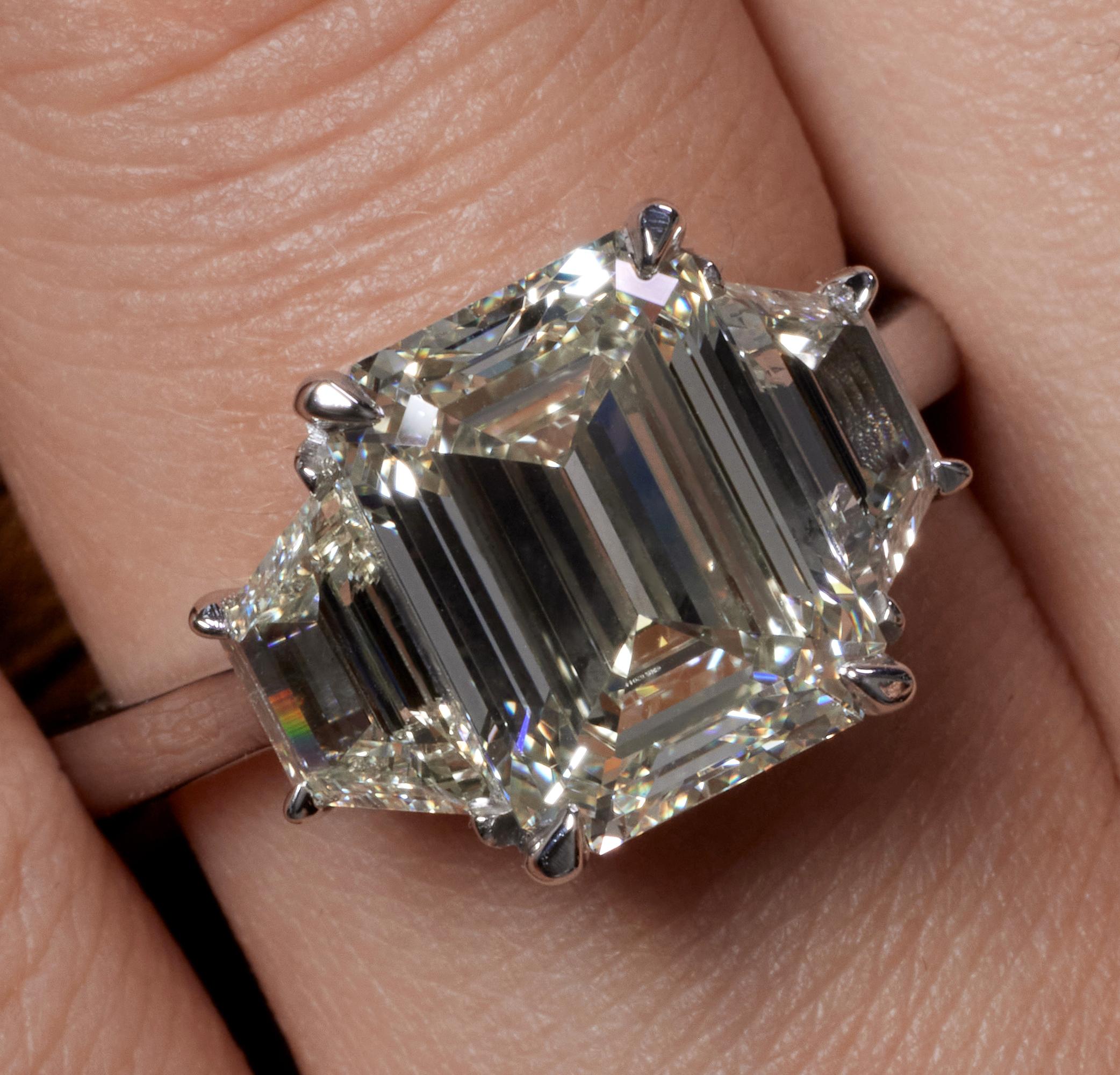 A Breathtaking Estate HANDMADE PLATINUM (stamped) Emerald Diamond Three-Stone Engagement ring. The Prong Set Emerald Diamond is 4.01CT with measurements of 10.42x7.82x4.94mm. GIA Certified as M color VS1 clarity (Warm White and Super Clear). 
Set