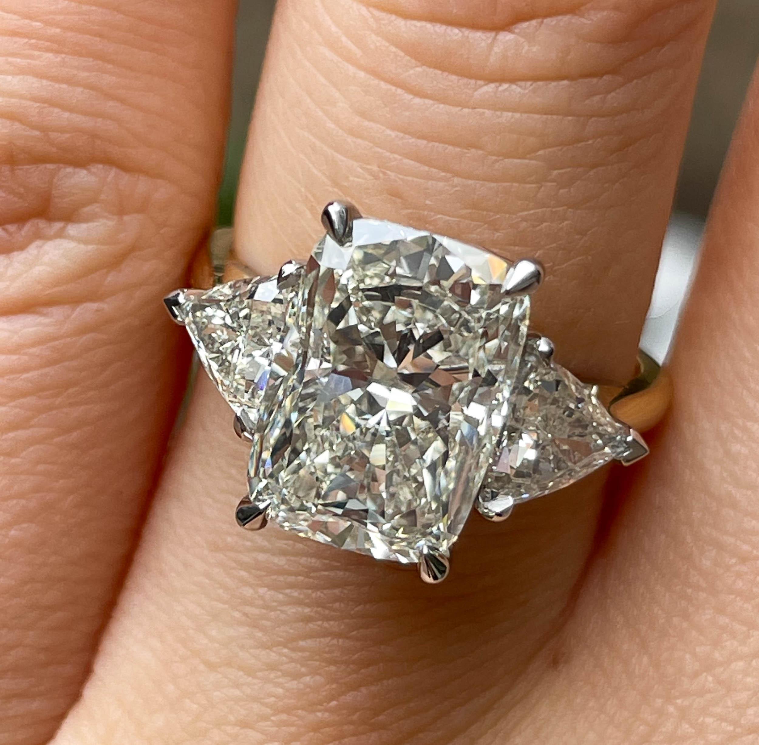 A Breathtaking Estate HANDMADE Platinum/18k Yellow Gold (stamped) Cushion Diamond Three-Stone Engagement ring contains GIA certified 4.13ct Cushion cut center diamond in M color and SI2 clarity; with measurements of 11.47x8.17x5.63mm. GIA report #