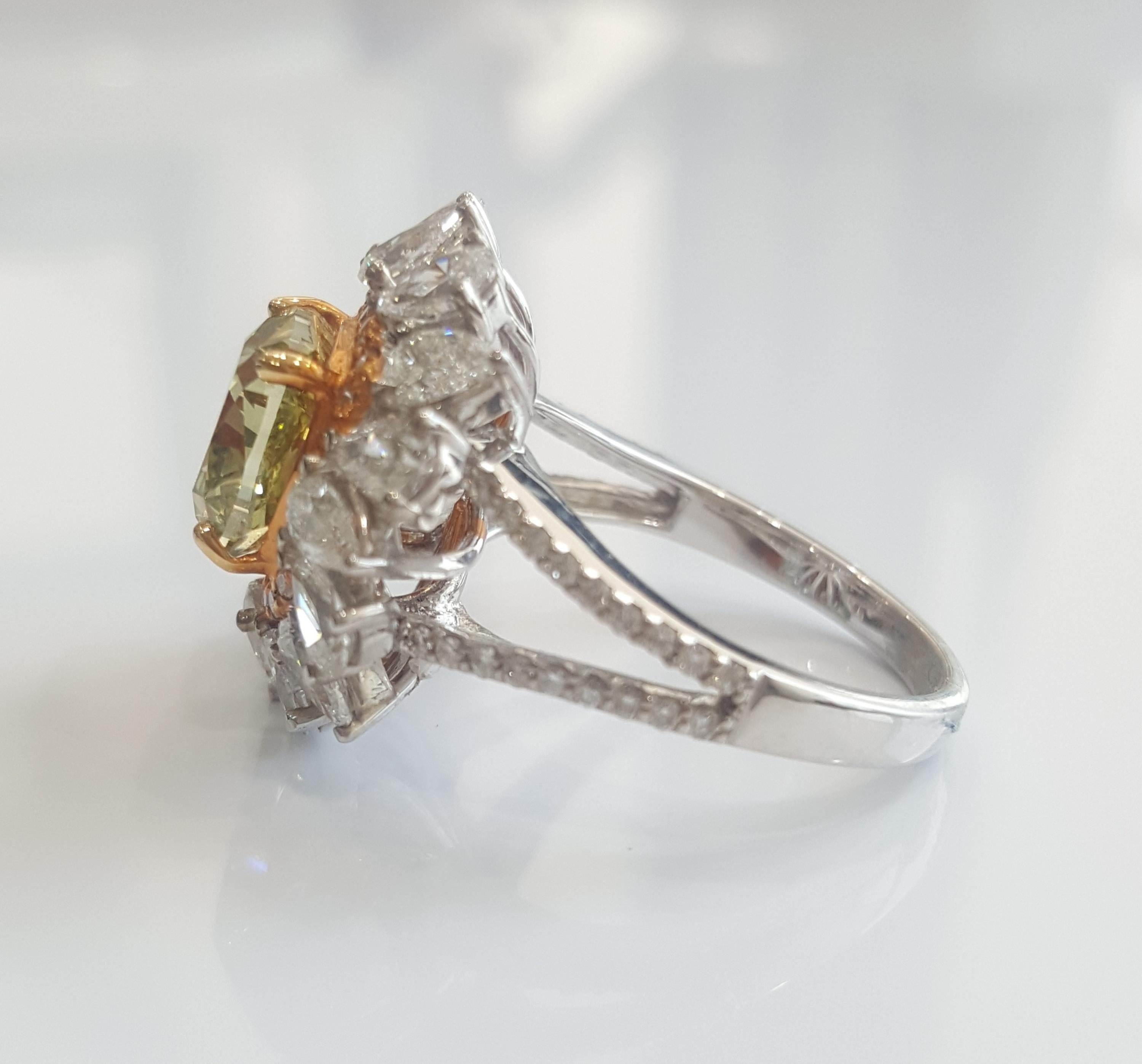This beautiful ring features a GIA certified Natural Fancy Deep Green Yellow Cushion Brilliant weighing 3.02 carat with VS1 clarity, set in the center of this magnificently detailed ring encased in the white small round brilliant cut diamonds