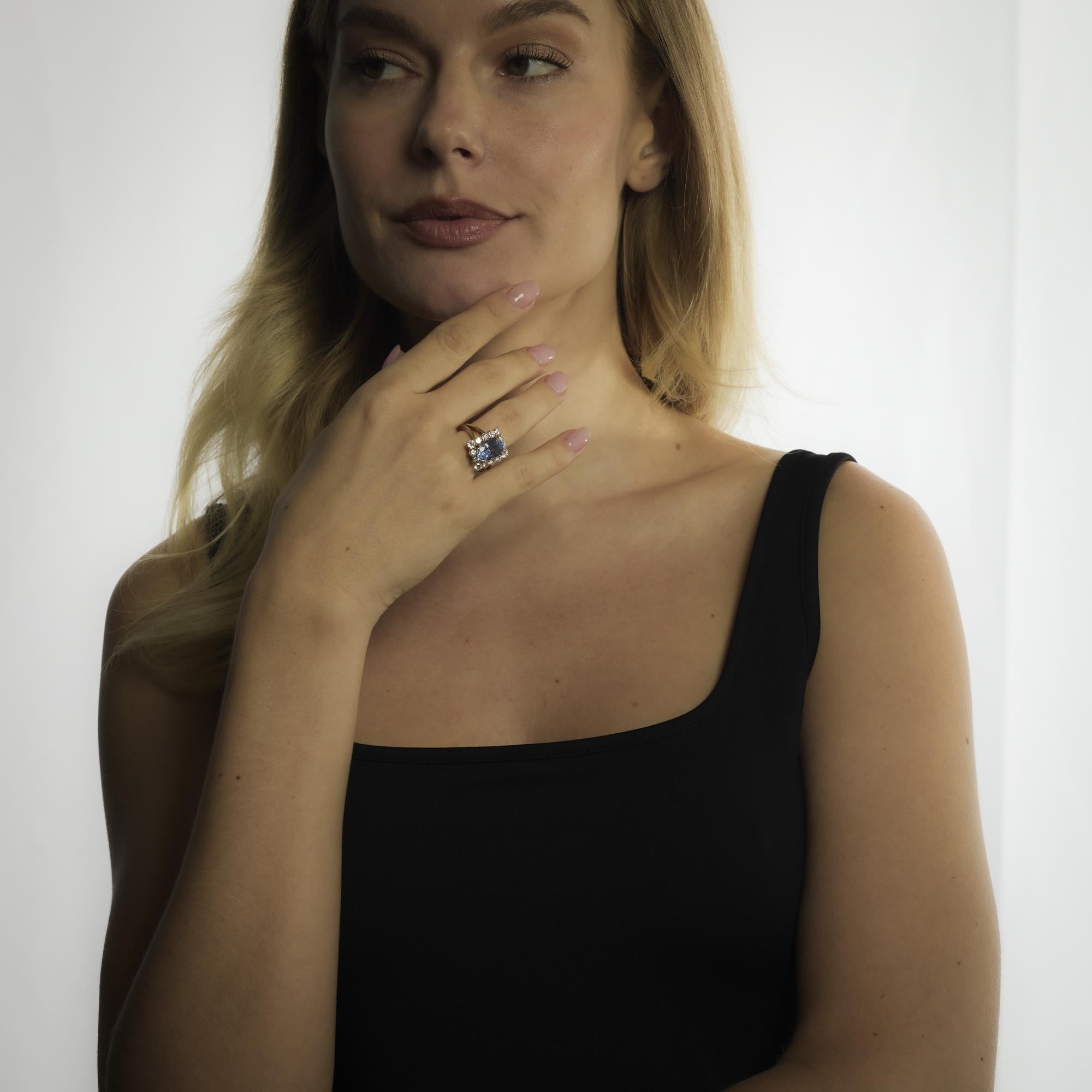 Questo anello vintage degli anni '80 mette in mostra un vibrante zaffiro di Ceylon da 5,51 carati in una ricca tonalità blu violacea, accentuato da 2,10 carati di diamanti rotondi taglio brillante in un radioso oro giallo 18 carati.